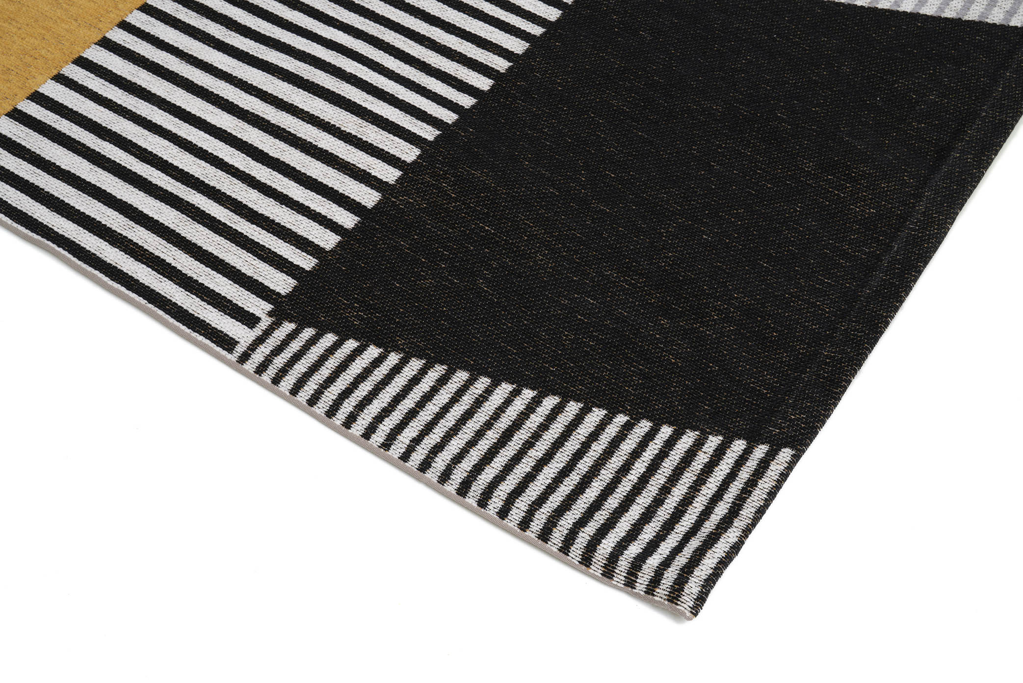 Bordure de tapis à rayures noires et blanches. Finition de qualité, ambiance moderne. Forme rectangulaire, couleurs neutres