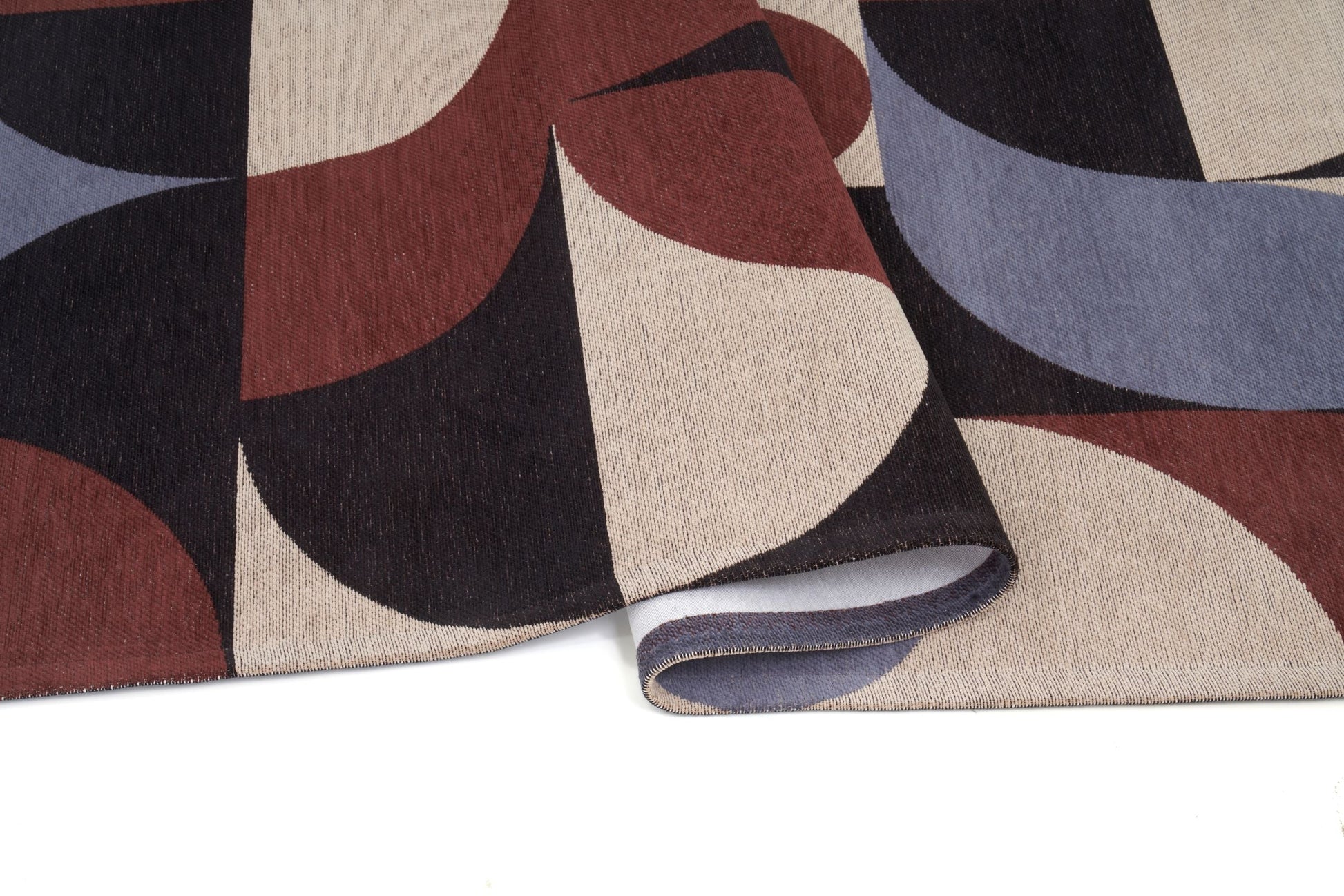 Tapis rectangulaire, motifs géométriques. Densité moyenne, aspect texturé. Confort apparent, couleurs chaudes