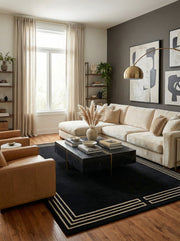 Tapis noir rectangulaire, bordure crème, salon moderne. Ambiance élégante, harmonie avec le décor