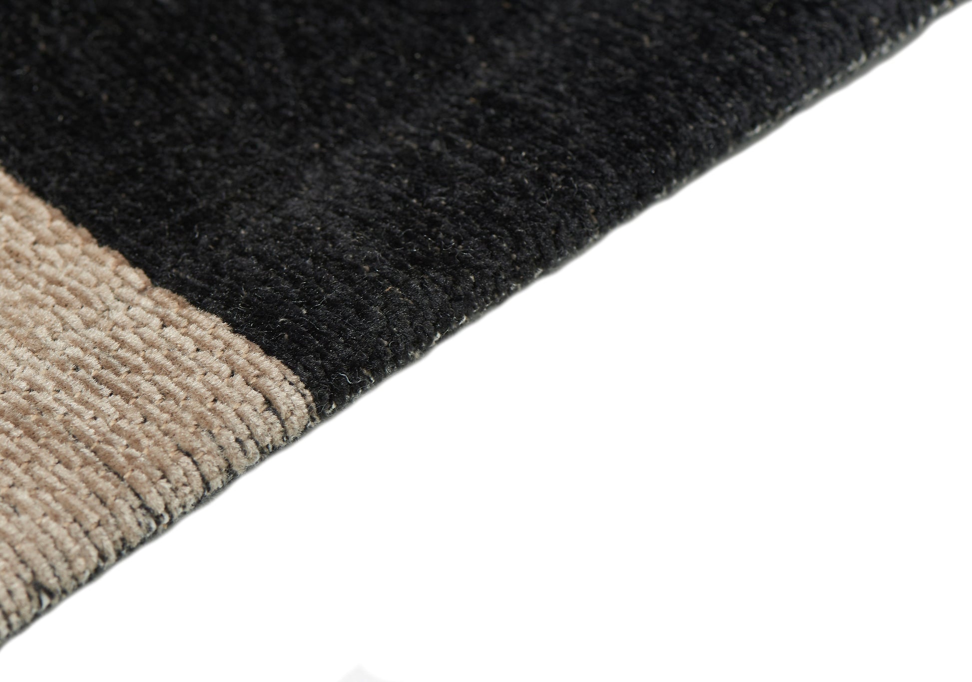 Tapis rectangulaire noir et beige. Densité et moelleux apparents, pour un confort visuel