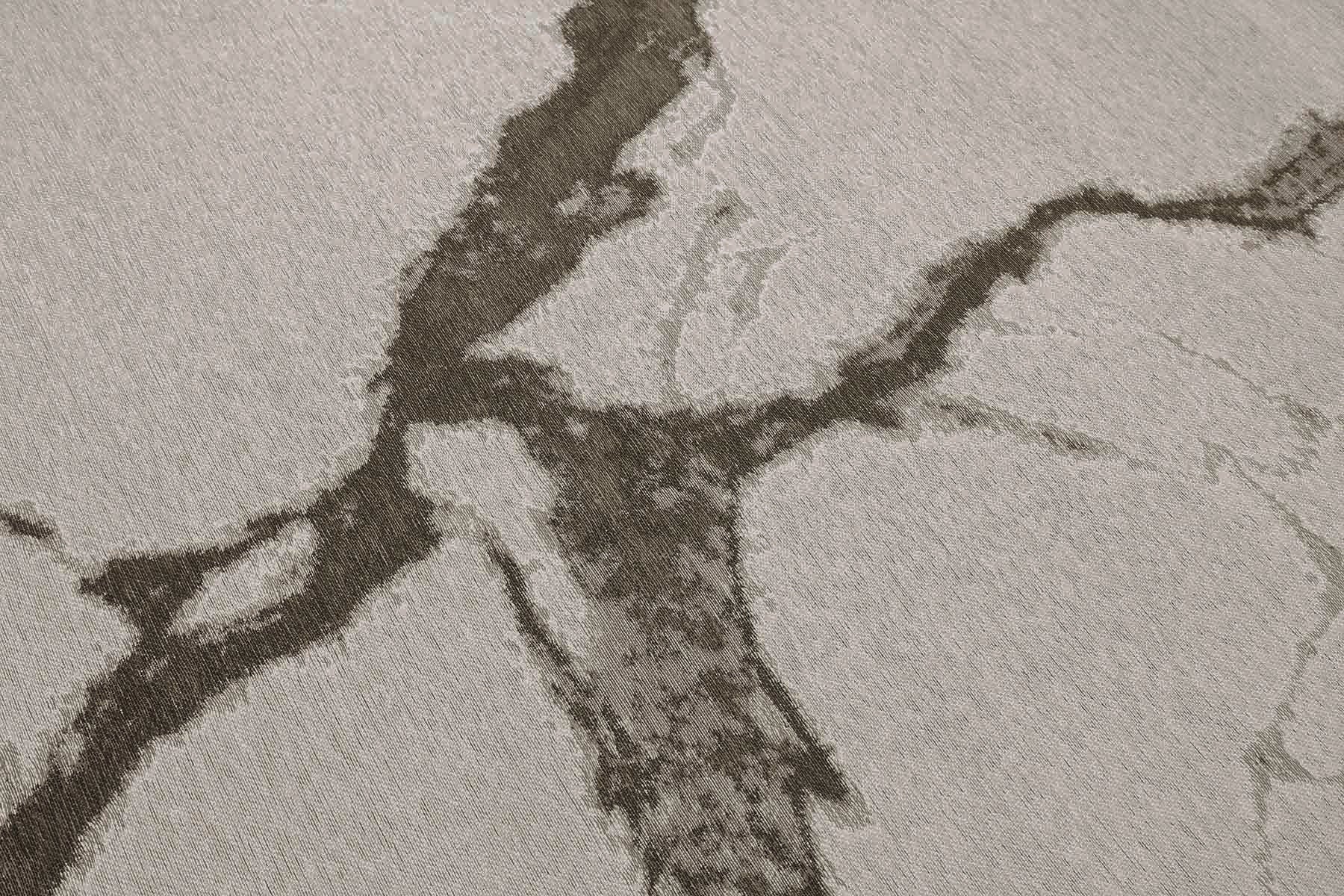 Tapis rectangulaire gris clair, tissage texturé avec motifs marbrés bruns. Relief subtil, aspect tactile et doux