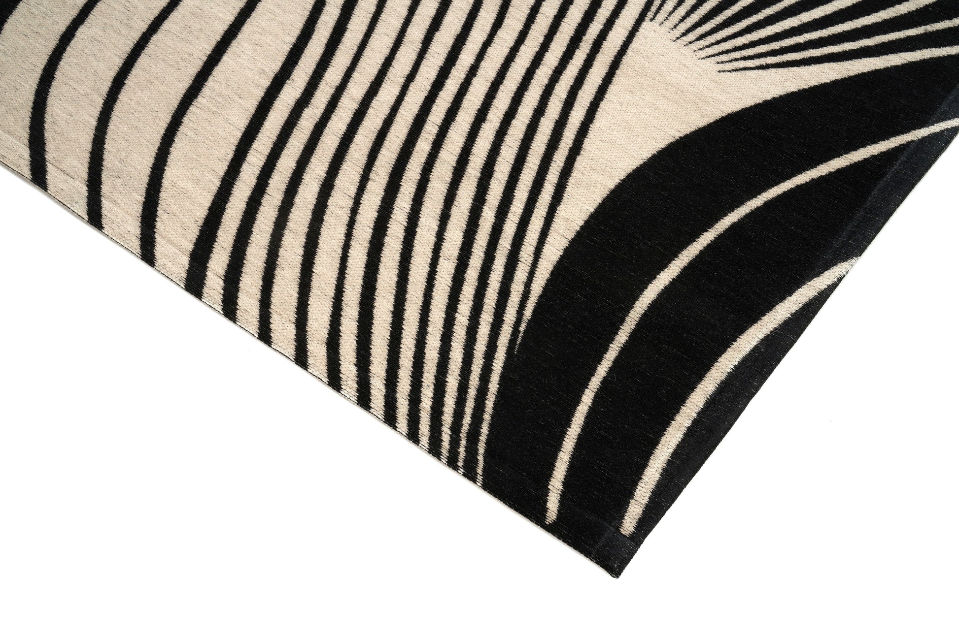Bordure de tapis noir et beige, finition de qualité. Forme rectangulaire, ambiance moderne