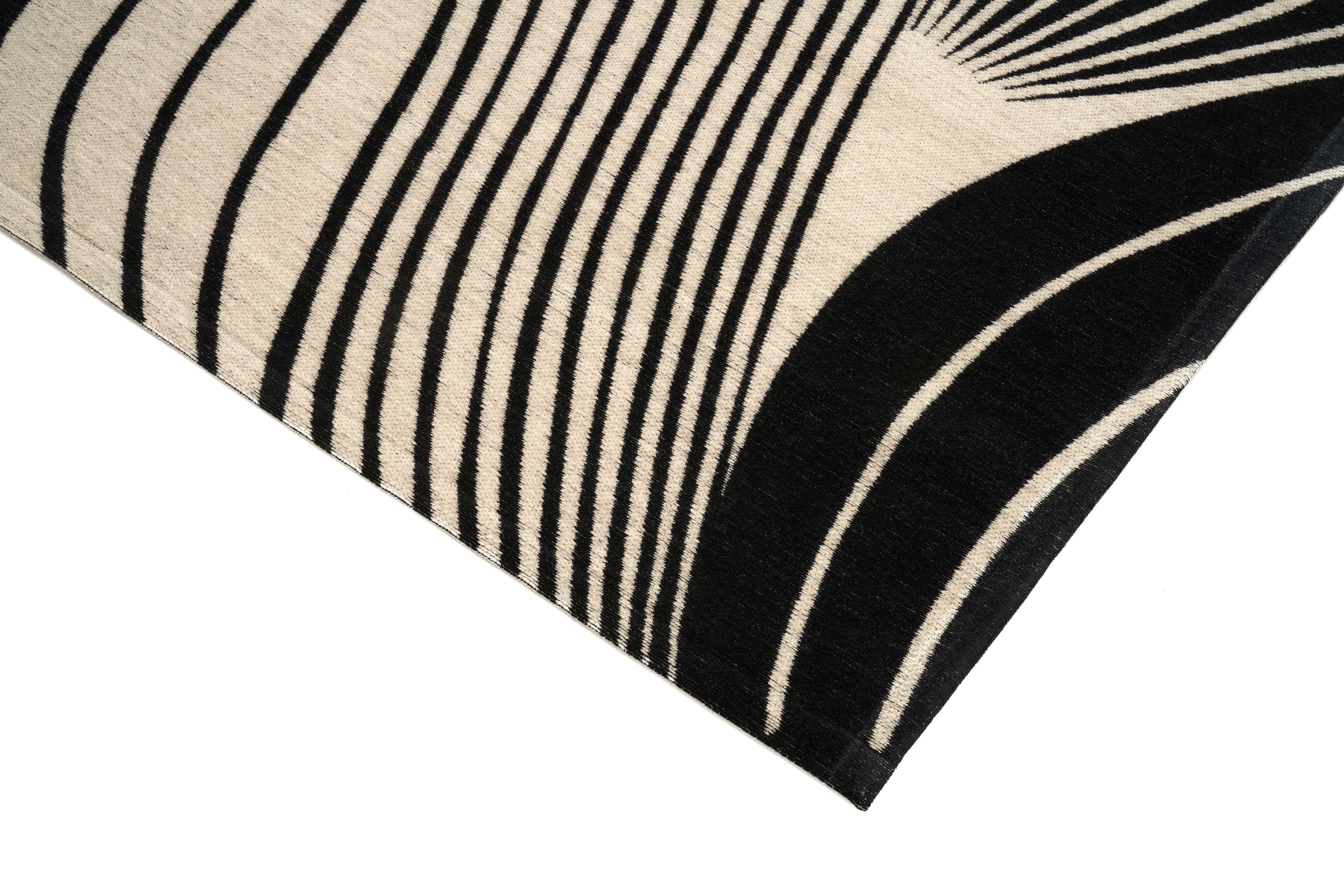 Bordure de tapis noir et beige, finition de qualité. Forme rectangulaire, ambiance moderne
