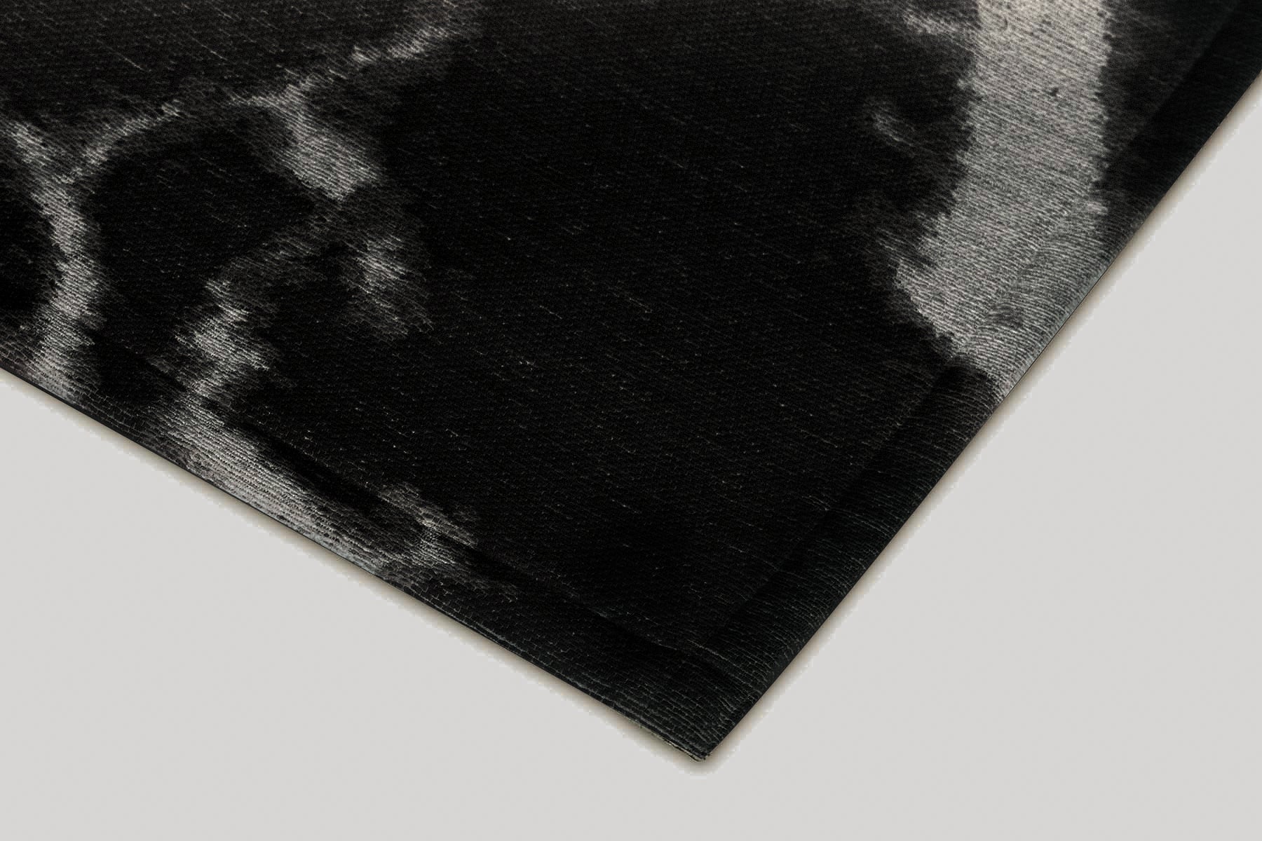 Bordure de tapis noir avec des motifs gris. Finition de qualité. Ambiance sombre. Forme rectangulaire