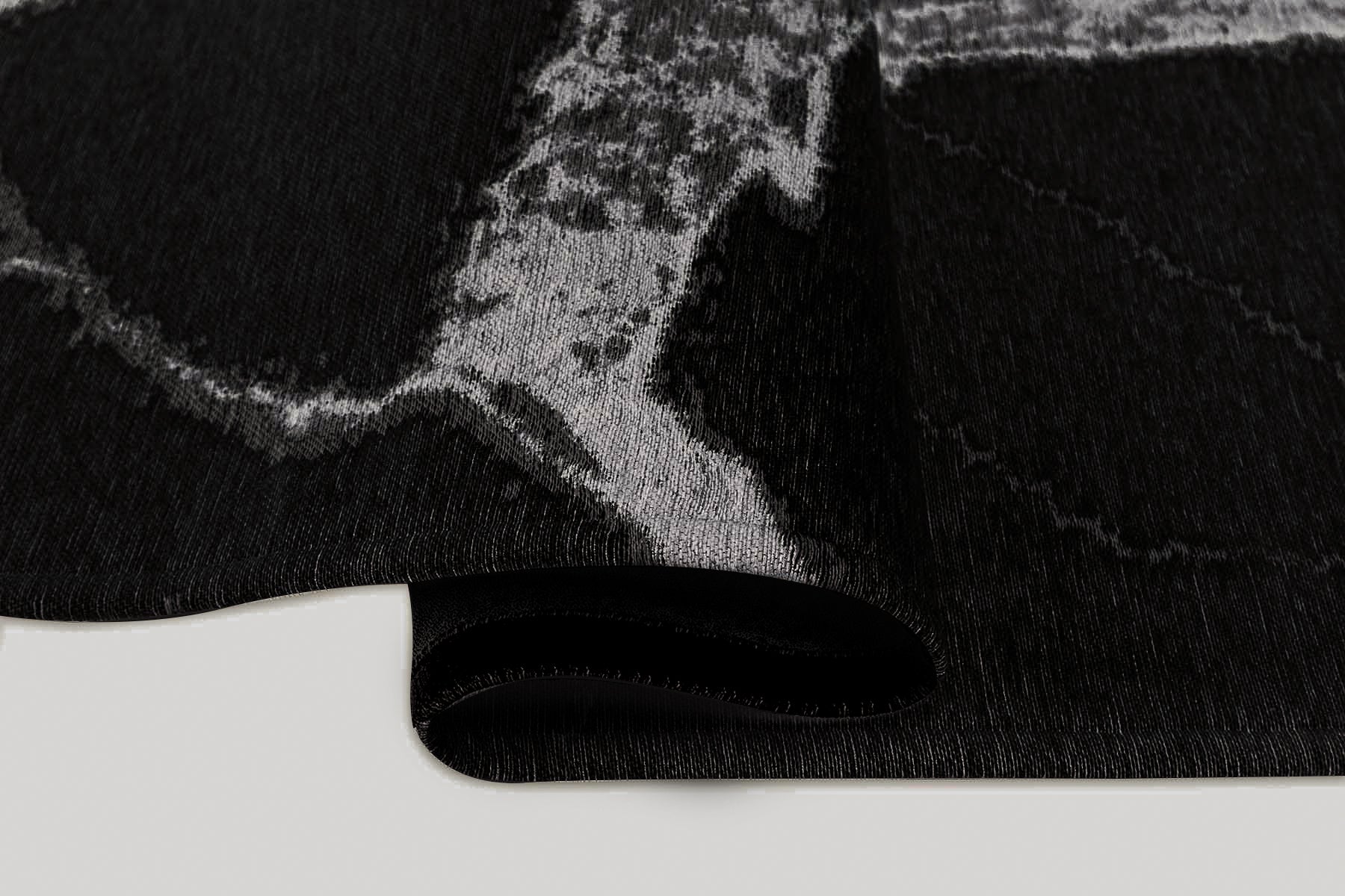 Tapis noir à motifs gris. Densité et moelleux apparents. Confort visuel. Ambiance feutrée