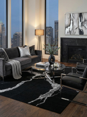 Tapis rectangulaire noir et blanc crée une ambiance moderne. Harmonie avec le décor sombre et élégant du salon