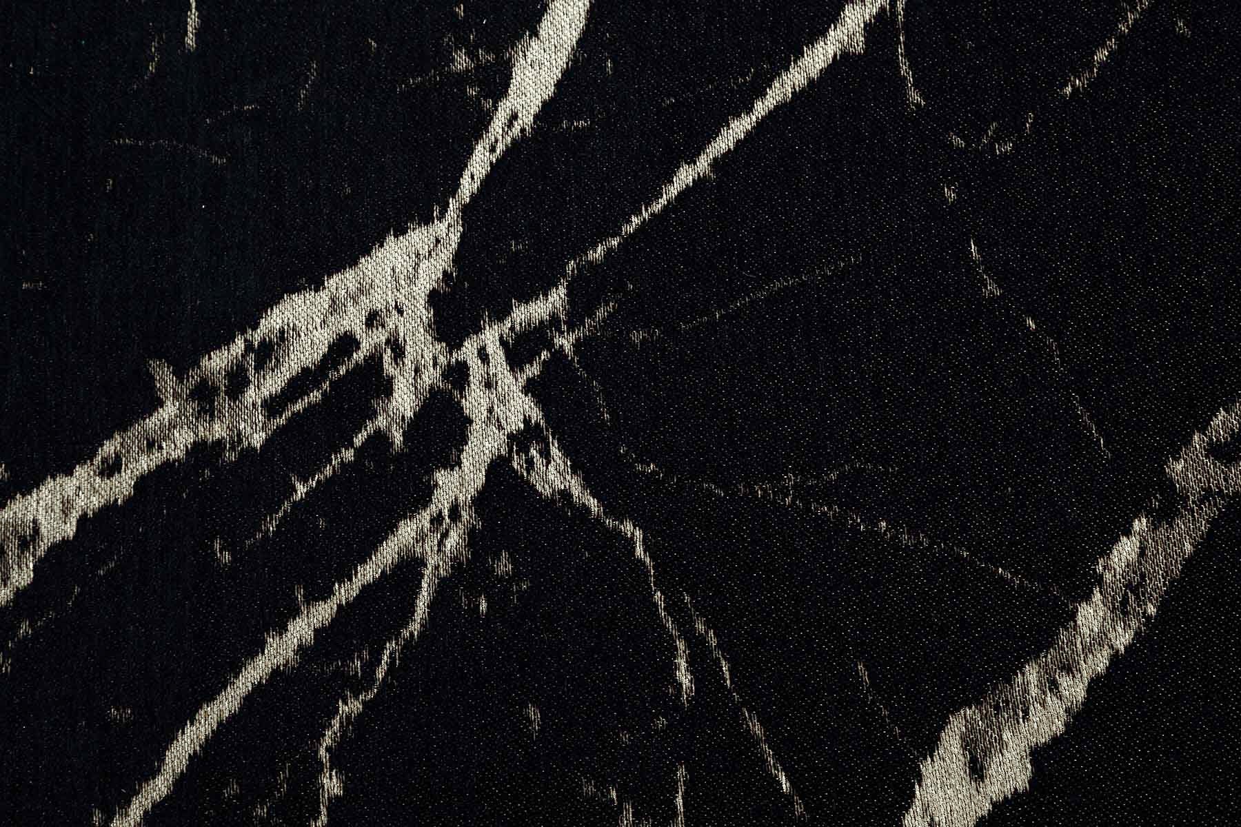 Gros plan sur un tapis moderne noir avec une texture effet marbre clair, idéal pour un intérieur contemporain et élégant.