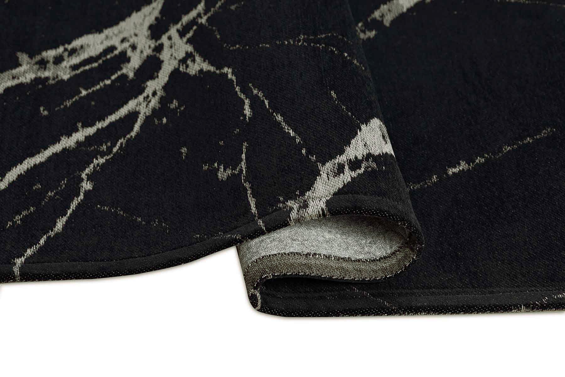 Tapis noir avec motifs beiges, densité et moelleux apparents, confort visuel