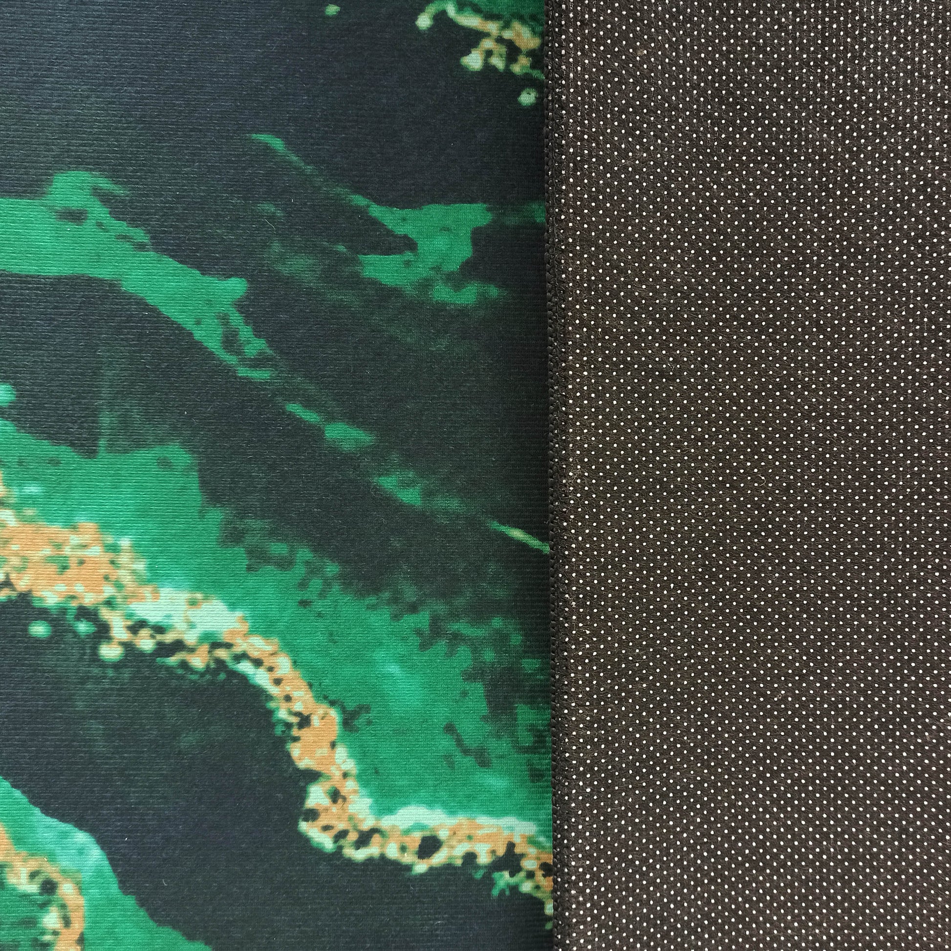 Tapis à la surface texturée marbrée vert foncé et noir, et au dos antidérapant gris à pois blancs