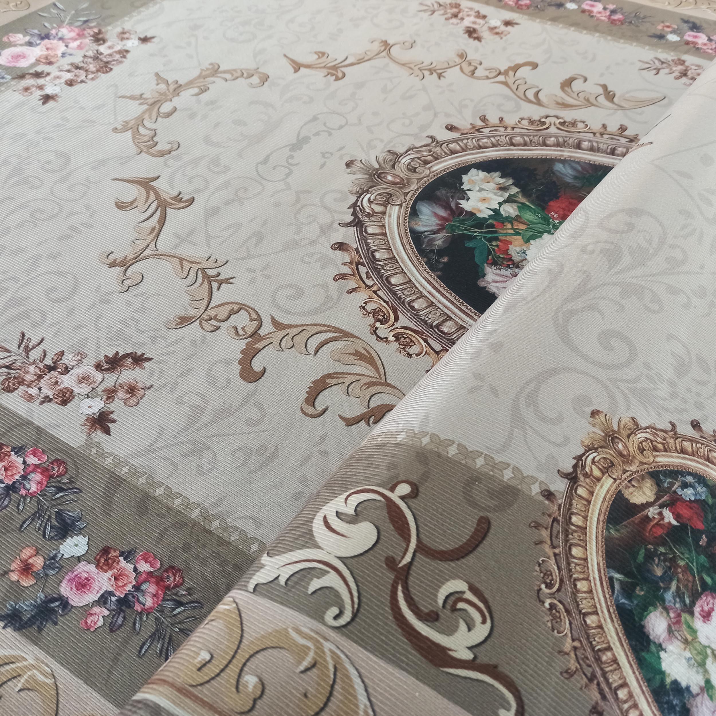 Tapis crème à motifs de volutes baroques marron et de fleurs colorées, incluant des bouquets encadrés d'or. Le tapis est plié