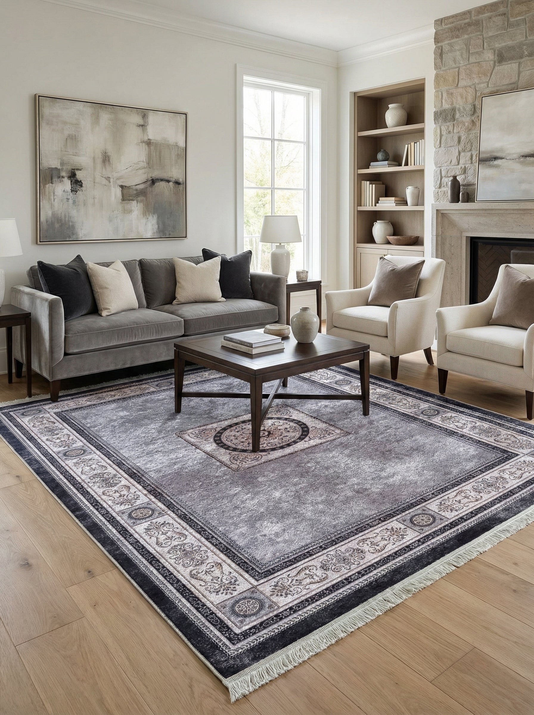 Tapis rectangulaire gris anthracite effet vieilli avec médaillon et large bordure à motifs classiques crème et noirs dans un salon