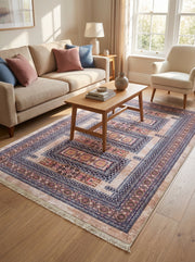 Tapis rectangulaire aux motifs traditionnels complexes beige, bleu foncé et rose avec franges claires dans un salon lumineux