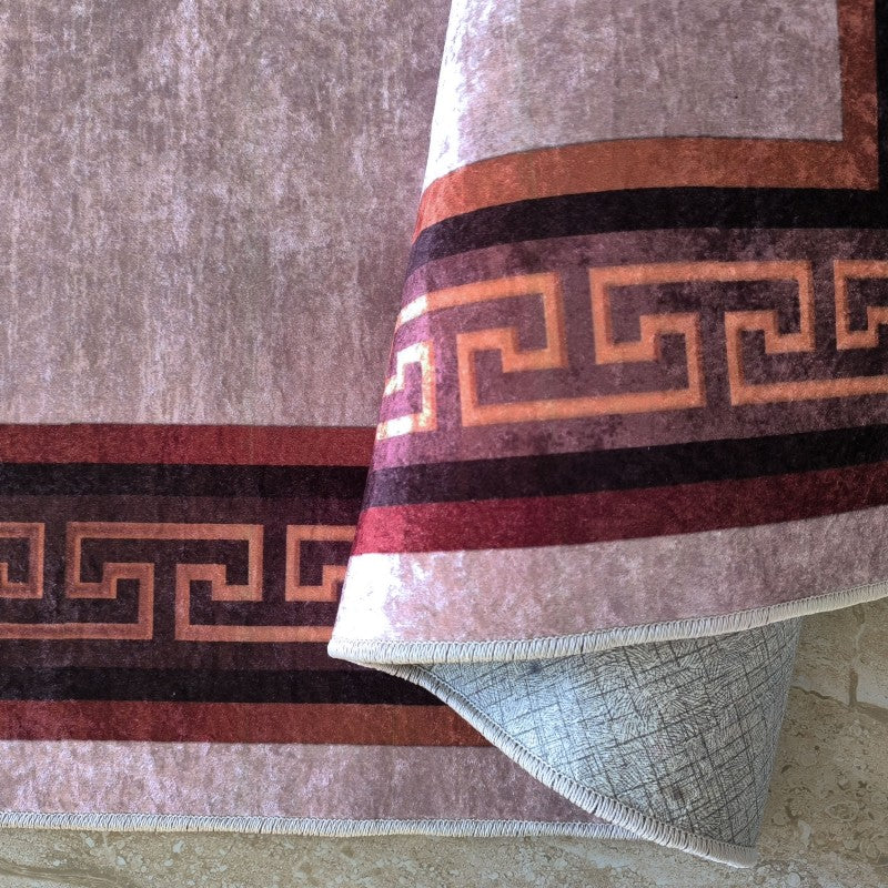 Tapis velouté beige avec une bordure à motif méandre grec en bandes marron, rouge et orange