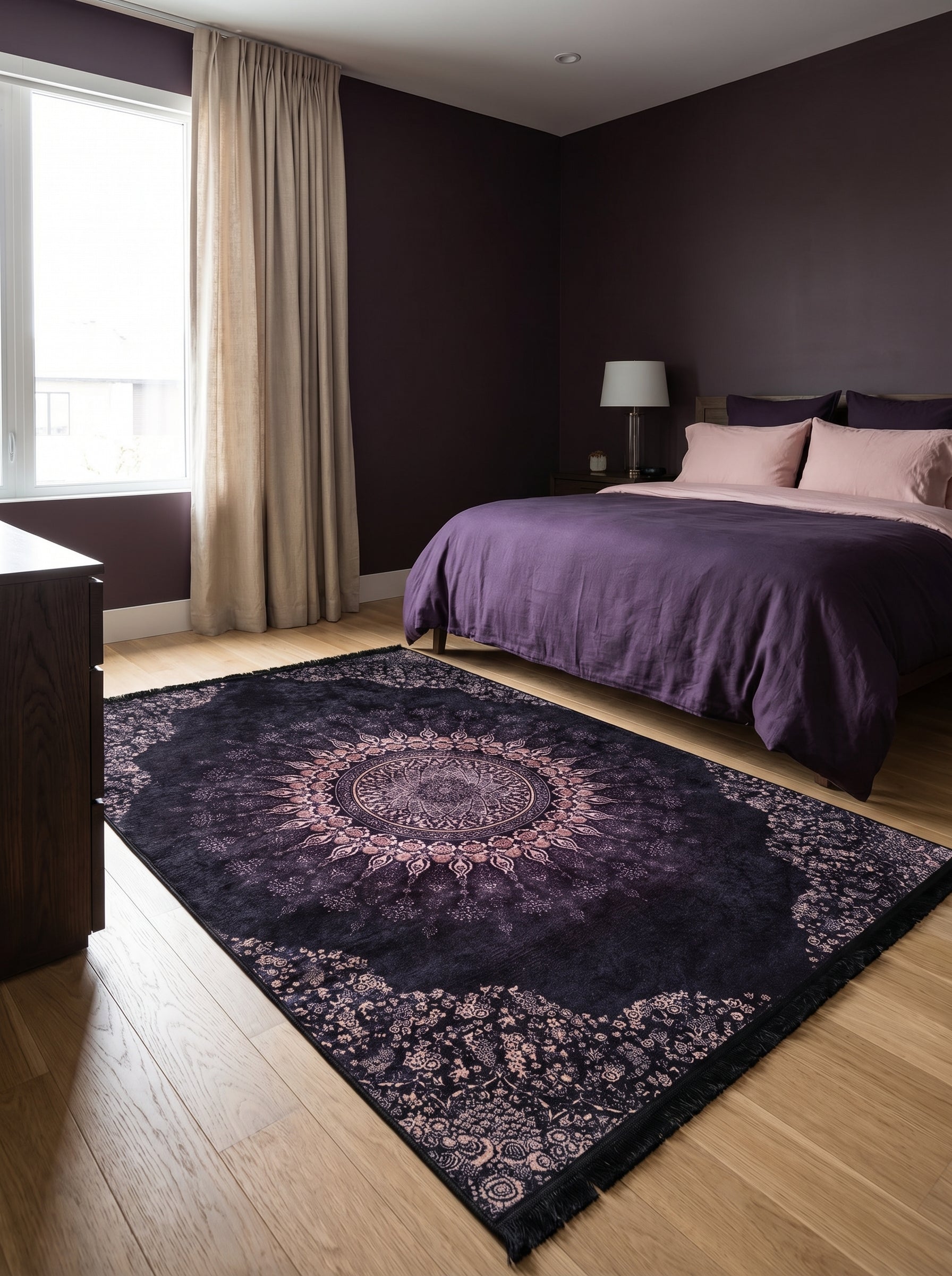 Tapis rectangulaire violet foncé et rose pâle, orné d'un motif mandala central et de bordures florales détaillées, dans une chambre