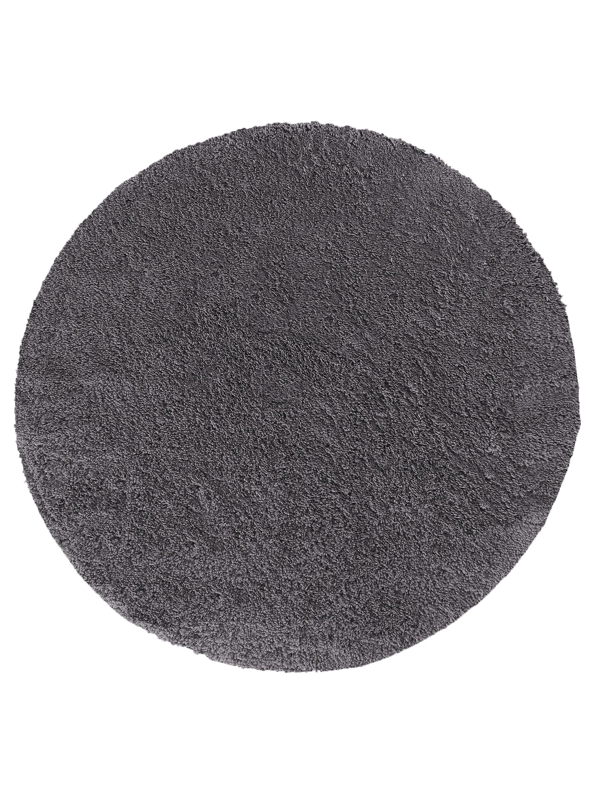Tapis rond gris foncé en fibres longues, avec une texture dense et moelleuse rappelant de la fourrure