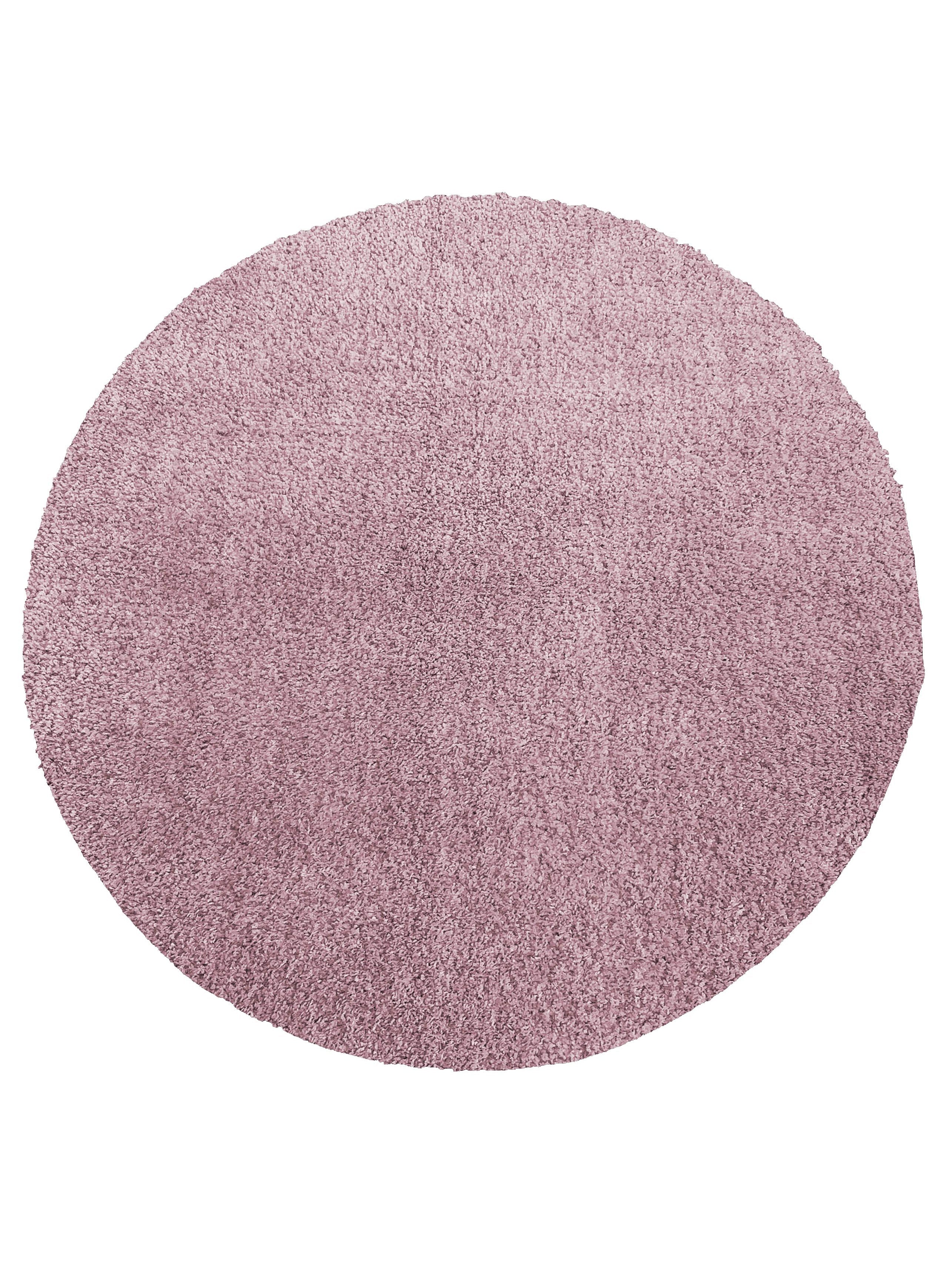 Tapis circulaire à poils longs, de couleur rose violacé, présentant une texture dense et moelleuse