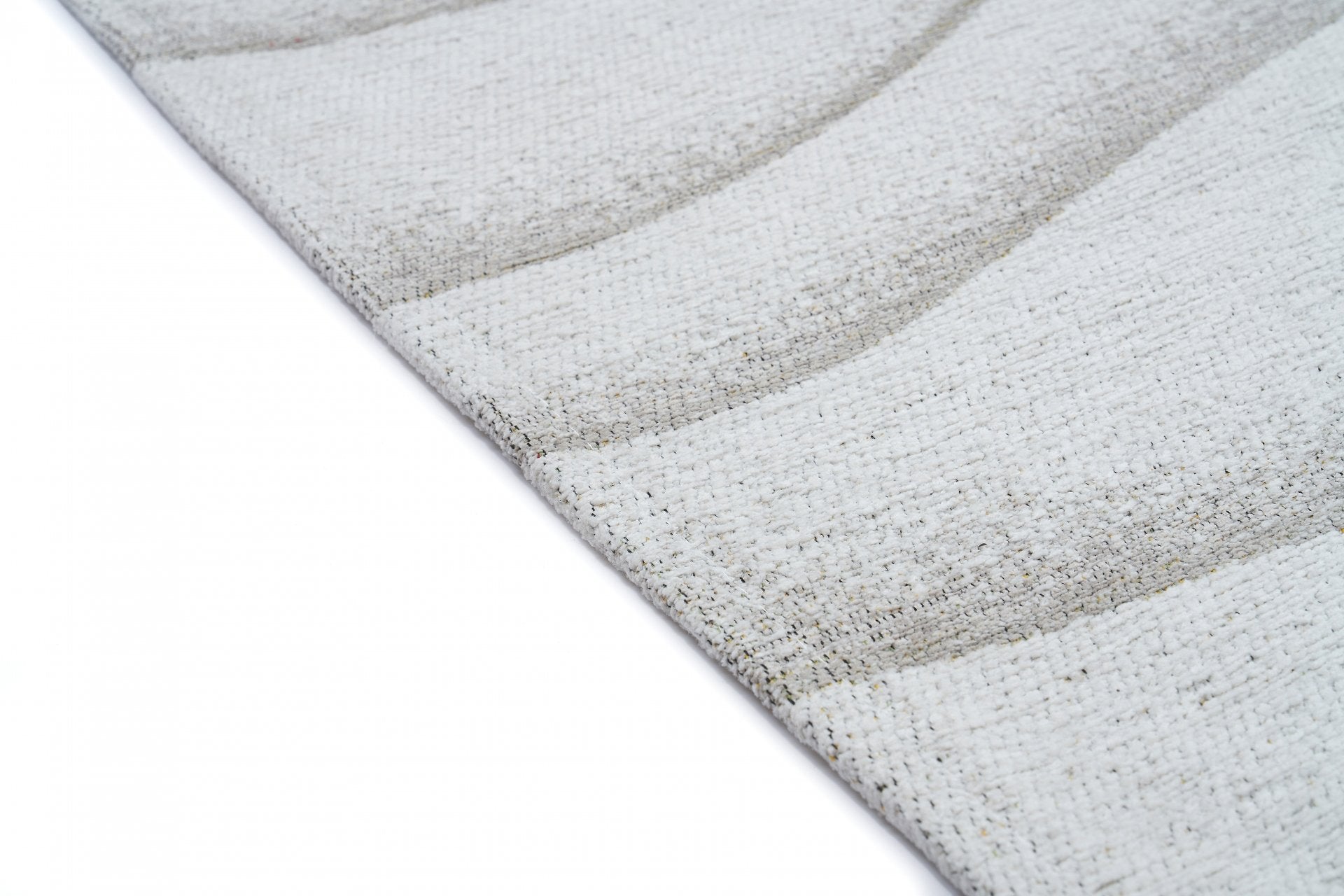 Tapis beige à tissage texturé, relief ondulé. Aspect tactile rugueux, ambiance sobre. Pièce rectangulaire