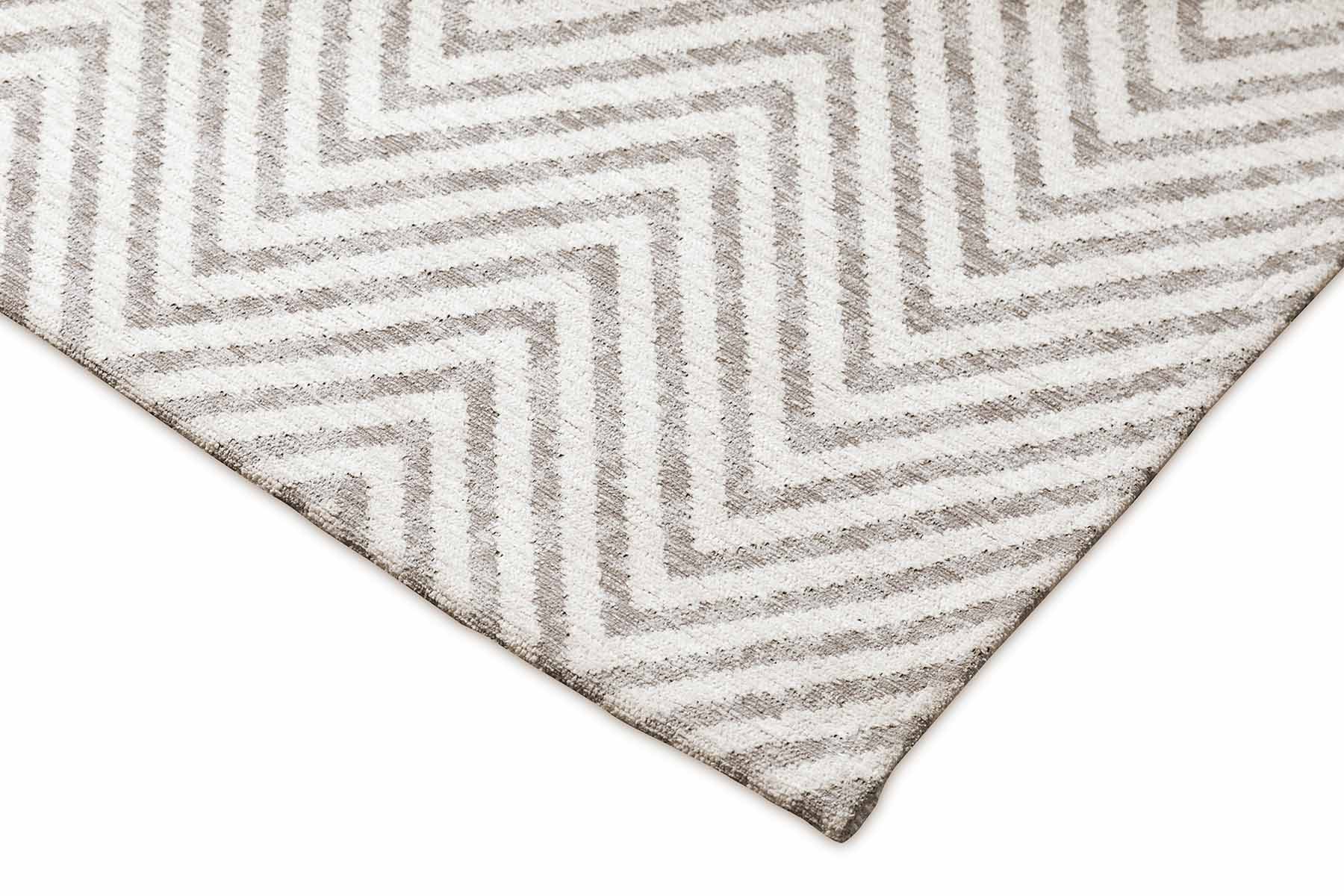 Bordure de tapis beige et grise. Finition de qualité, motif chevron. Ambiance neutre