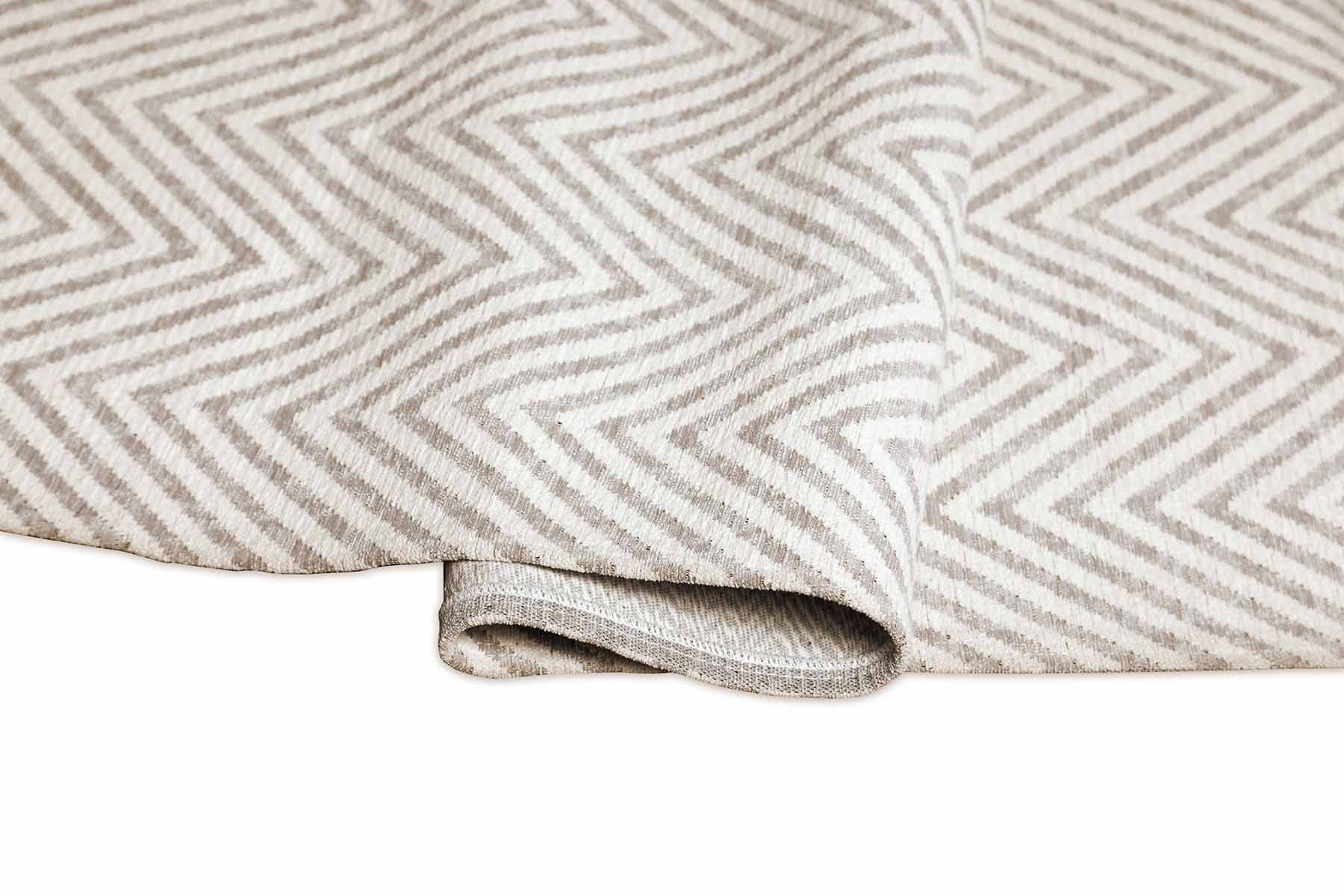 Tapis rectangulaire à chevrons beige et blanc. Tissu dense, moelleux, pour un confort visuel