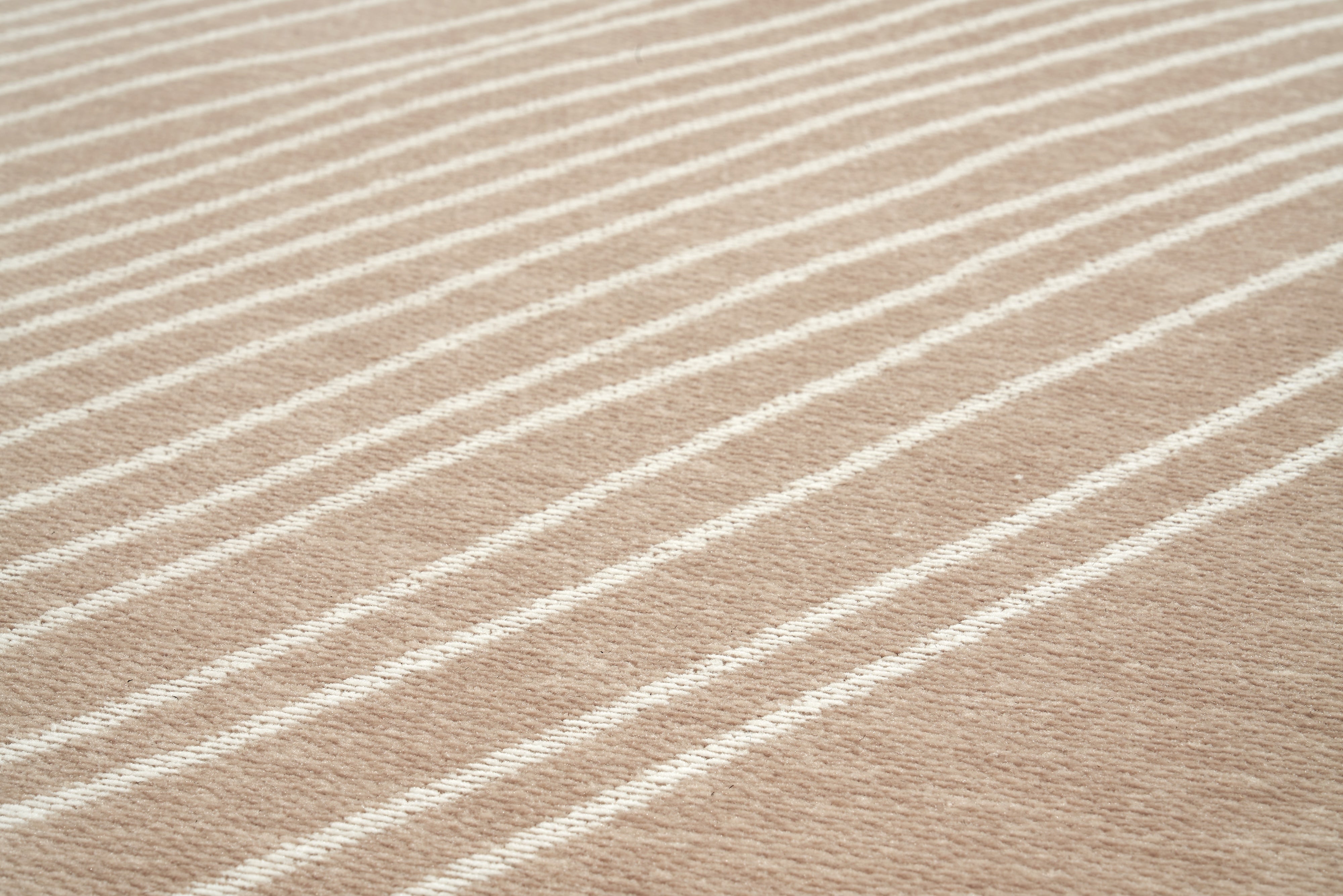 Tapis rectangulaire beige à rayures blanches. Tissage texturé avec relief. Aspect tactile doux