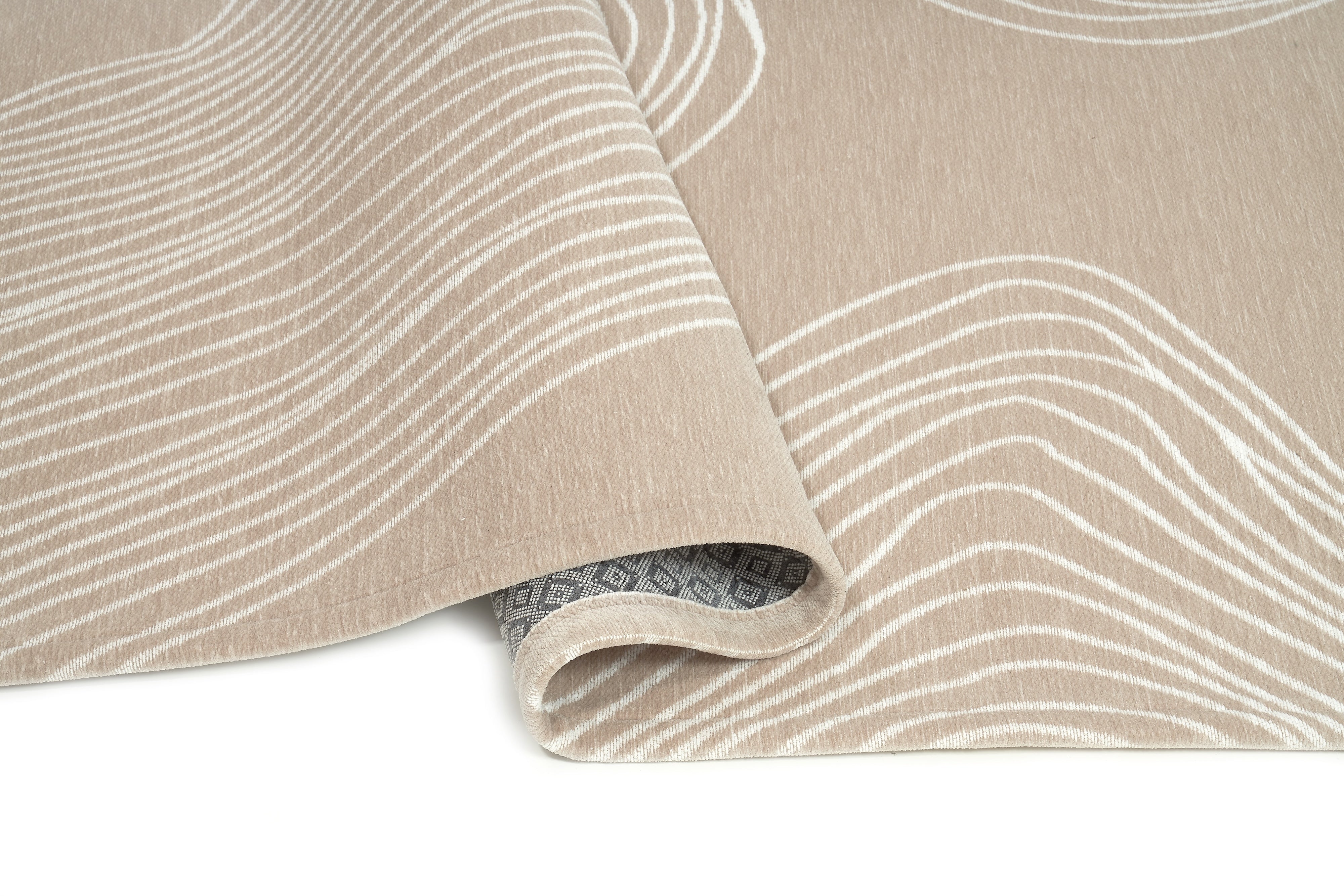 Tapis rectangulaire beige à motifs ondulés blancs. Apparence dense, moelleuse, pour un confort visuel