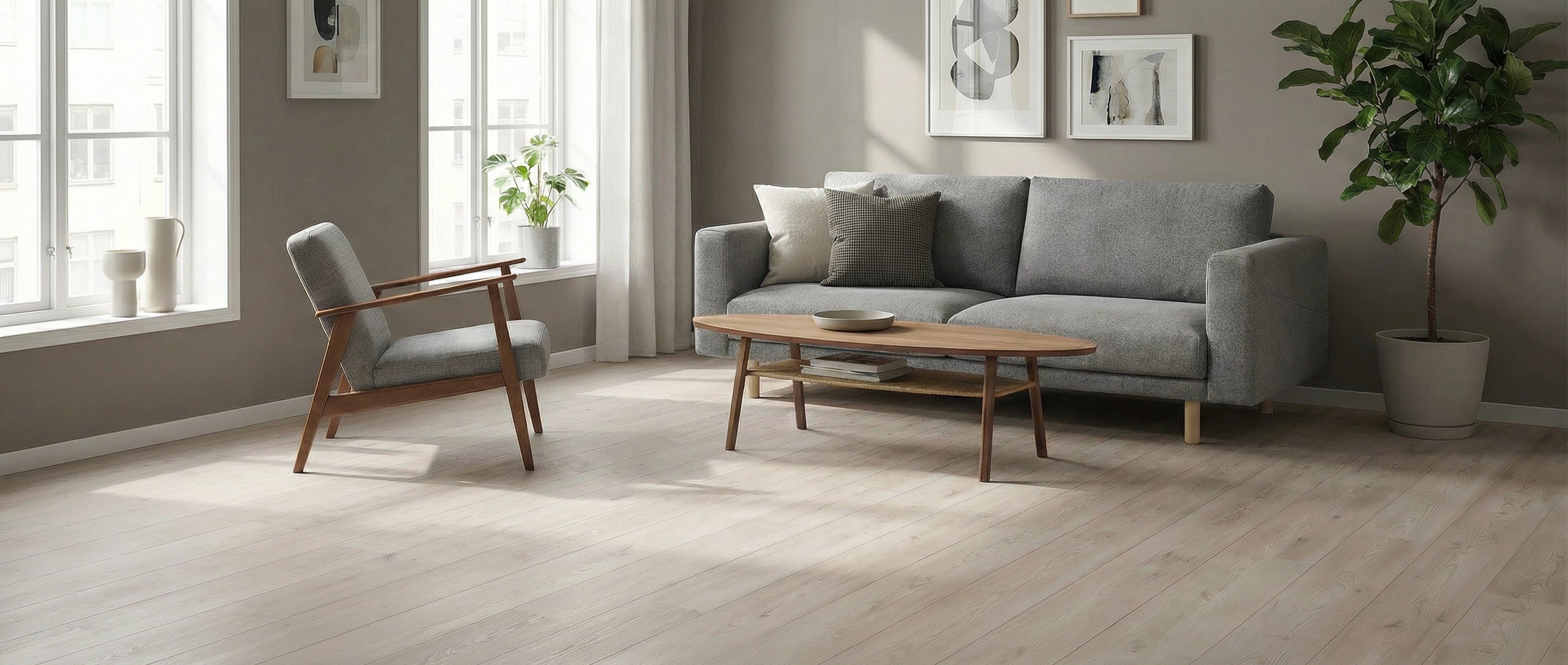 Pièce lumineuse avec parquet clair. Canapé gris, fauteuil, table ovale en bois. Potentiel déco, espace vide