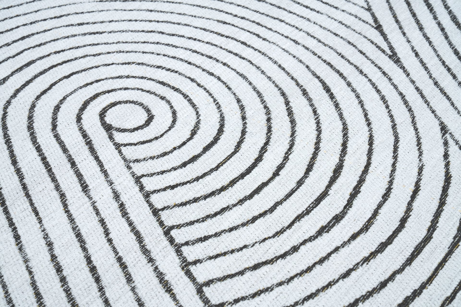 Zoom sur le tapis scandinave blanc Nimbus avec motif de lignes noires courbes pour un effet visuel texturé et moderne.