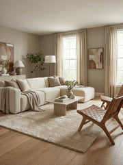 Tapis rectangulaire beige clair, moelleux et uni, posé sur un parquet dans un salon moderne