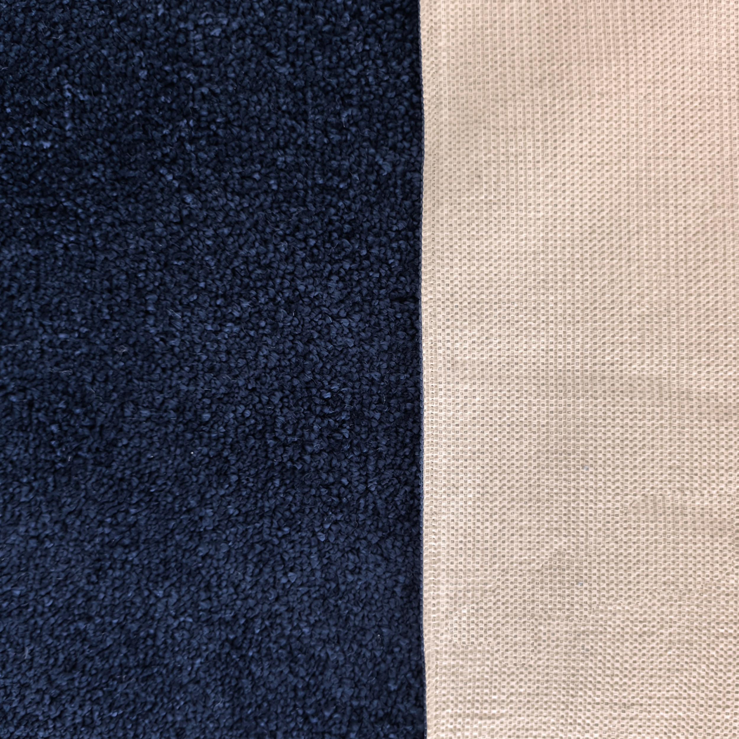 Tapis bicolore présentant une section bleu foncé à la texture douce et une section beige clair finement tissée