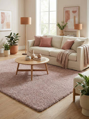 Tapis rectangulaire rose poudré, épais et texturé à poils longs, couvrant la majeure partie du sol d'un salon lumineux