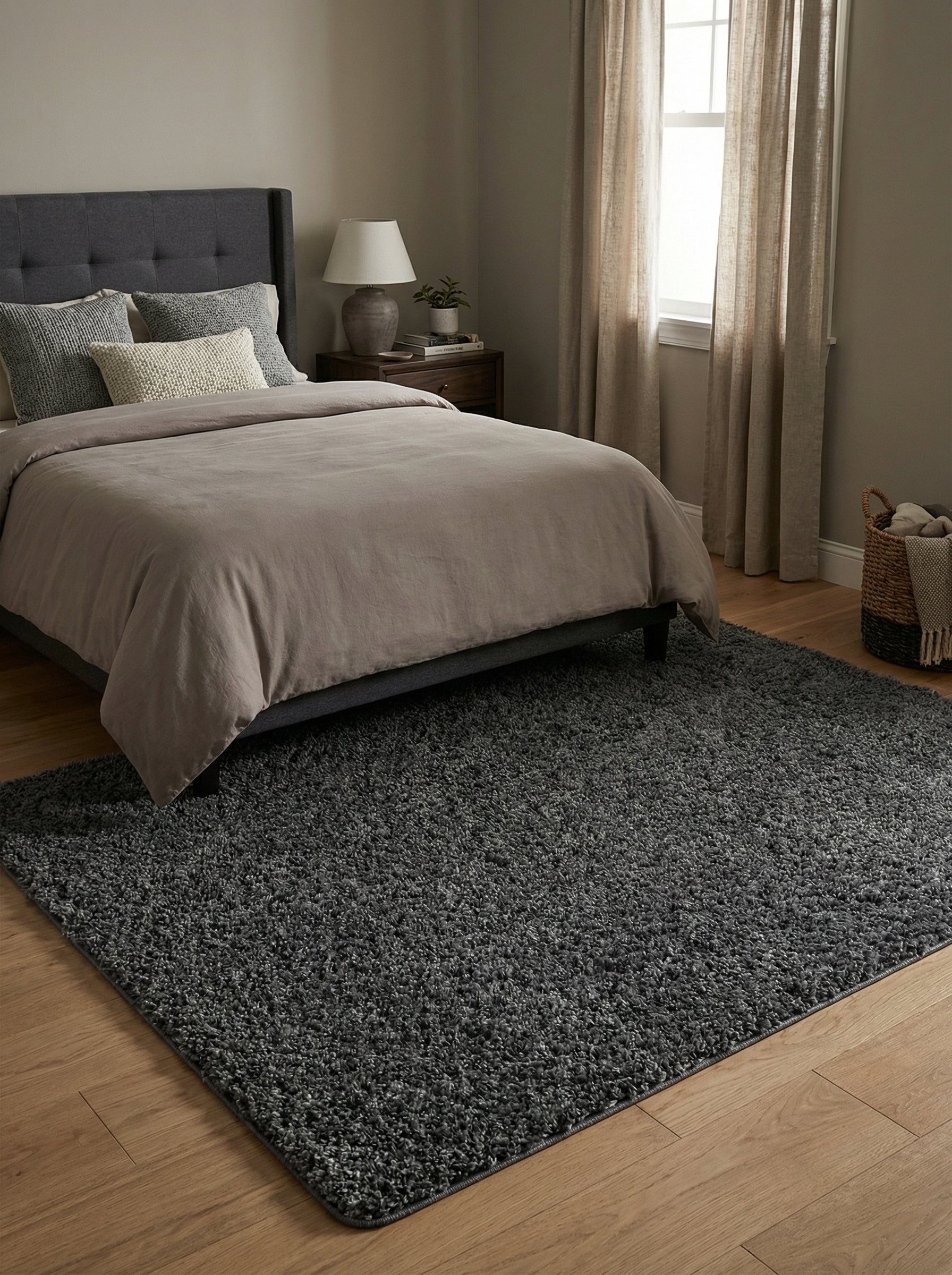 Grand tapis shaggy gris anthracite rectangulaire posé sur un parquet clair dans une chambre à coucher moderne