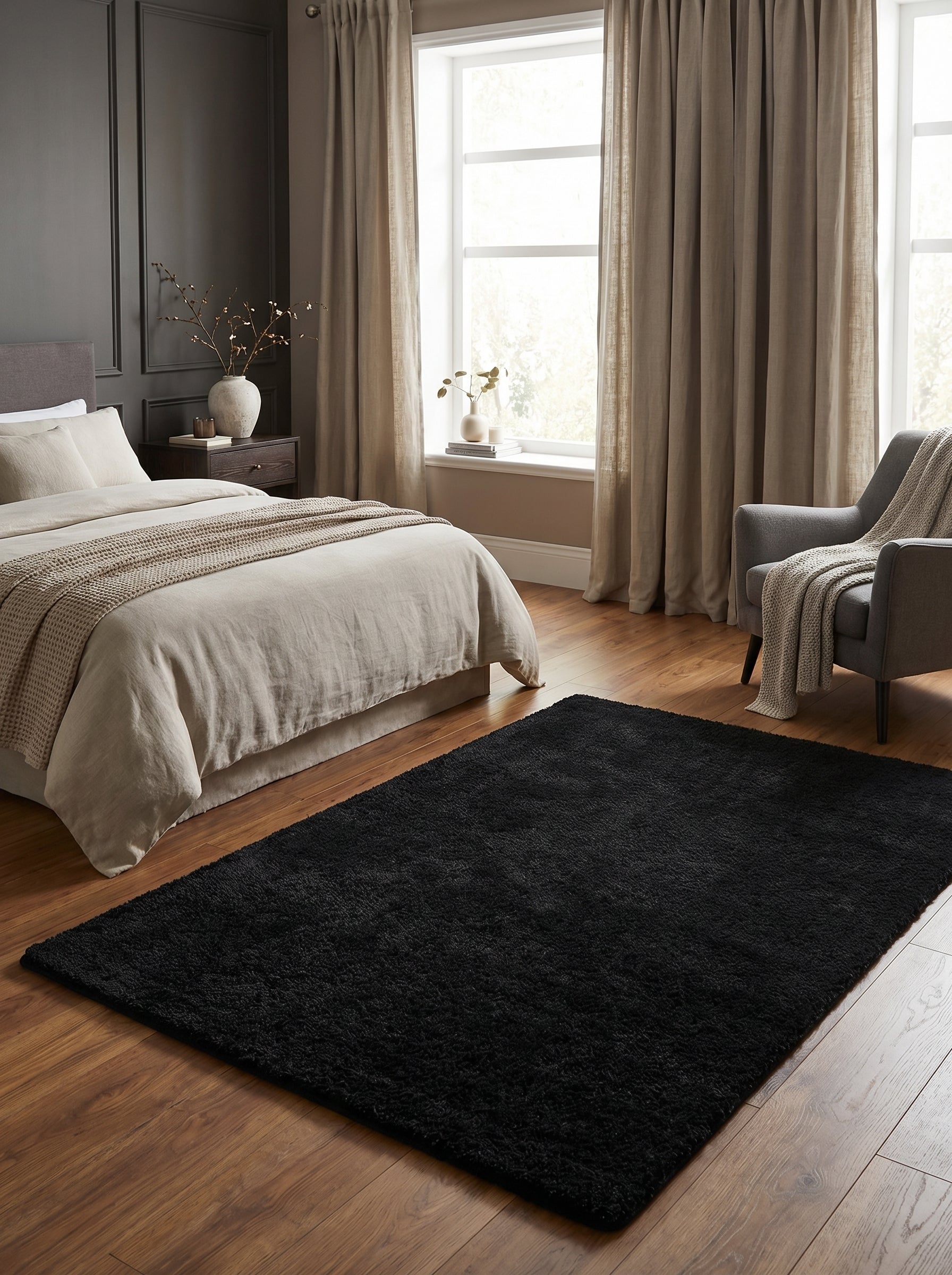 Tapis rectangulaire shaggy noir sur parquet en bois, dans une chambre à coucher moderne