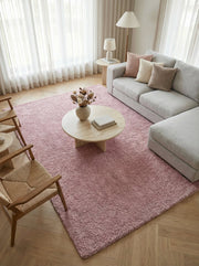 Tapis rose poudré rectangulaire à texture shaggy et épaisse, apportant chaleur à un salon moderne et lumineux