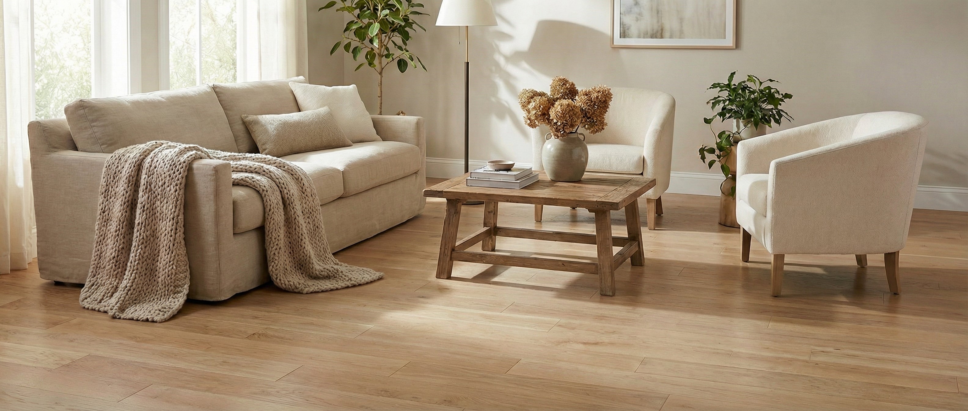 Pièce lumineuse avec canapé, fauteuils beiges, table basse en bois et parquet clair. Espace vide pour un tapis rectangulaire