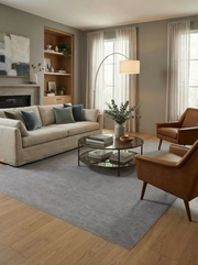 Tapis gris rectangulaire dans un salon. Ambiance feutrée, harmonie avec le décor aux tons neutres