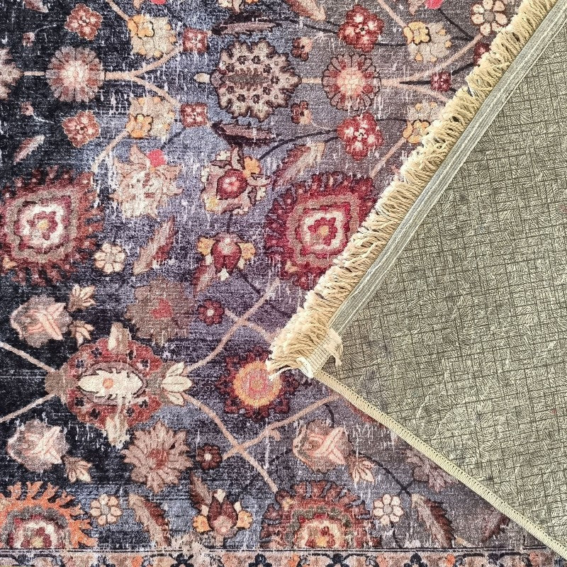 Tapis texturé à motifs floraux vieillis en rouge, orange et beige sur fond bleu foncé, franges claires et envers visible