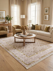 Tapis rectangulaire rose pâle et or avec motifs floraux classiques et bordure, posé sur un parquet en bois clair dans un salon