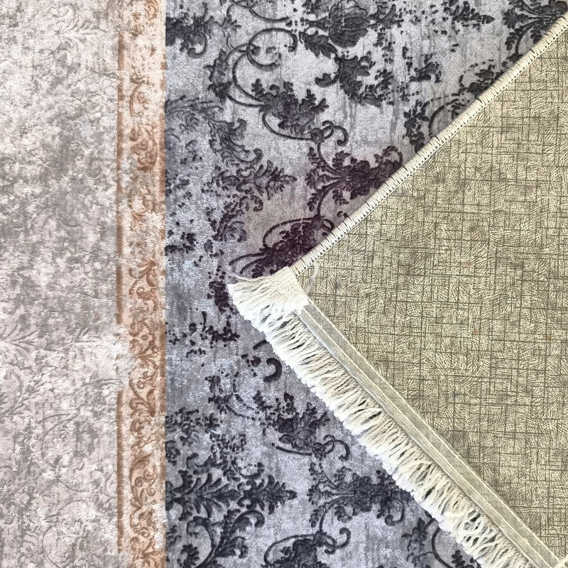 Tapis gris à motifs floraux foncés et son envers tissé beige, avec des franges blanches et un autre tapis à bordure ornée