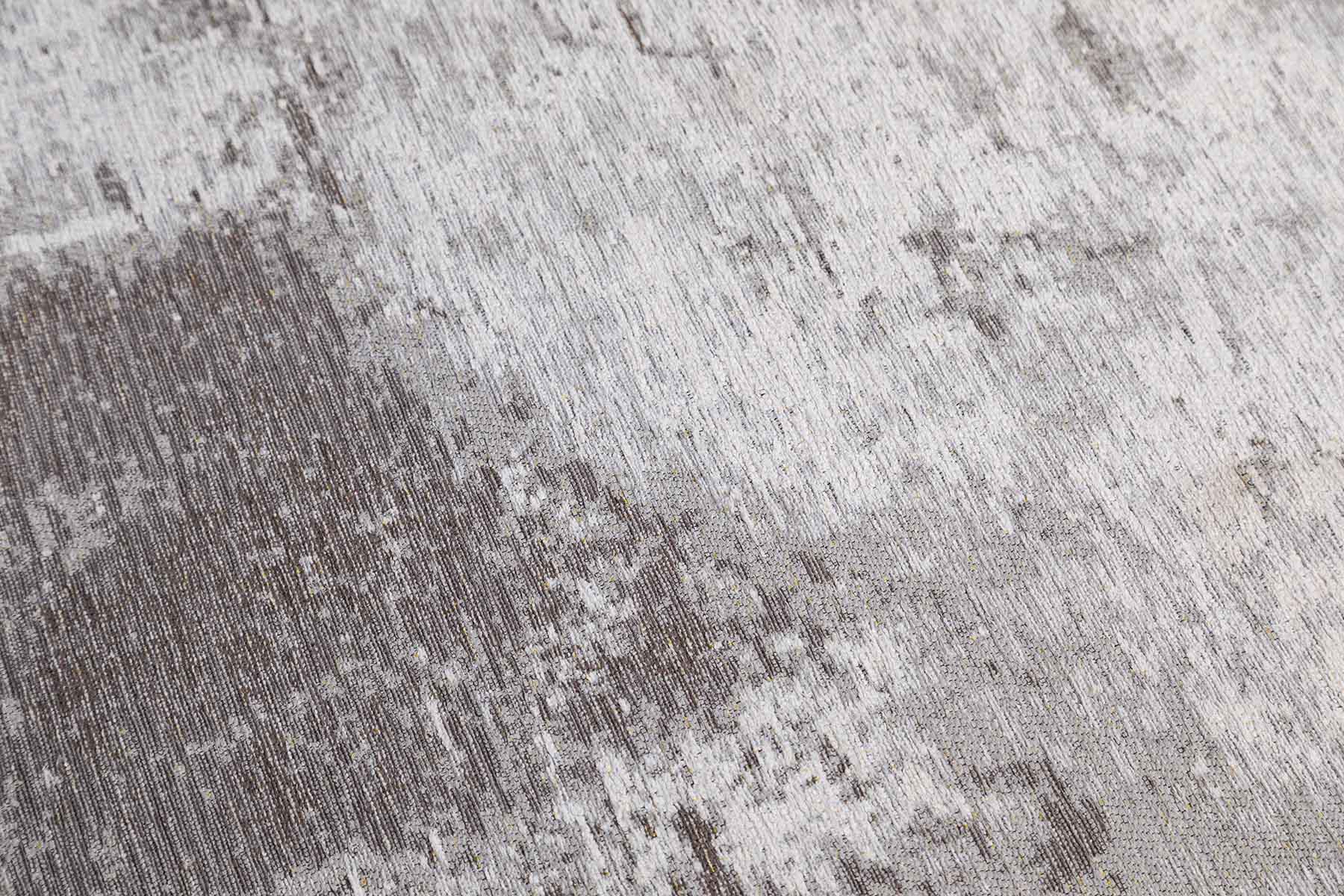 Gros plan sur un tapis vintage massif gris lavable avec des fibres et une texture usagée et intéressante.