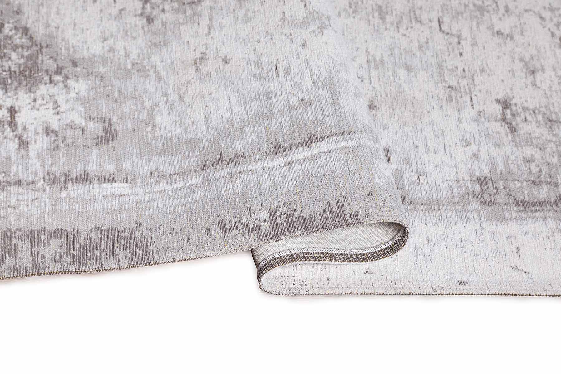 Tapis rectangulaire gris. Densité moyenne, moelleux. Confort apparent. Ambiance sobre