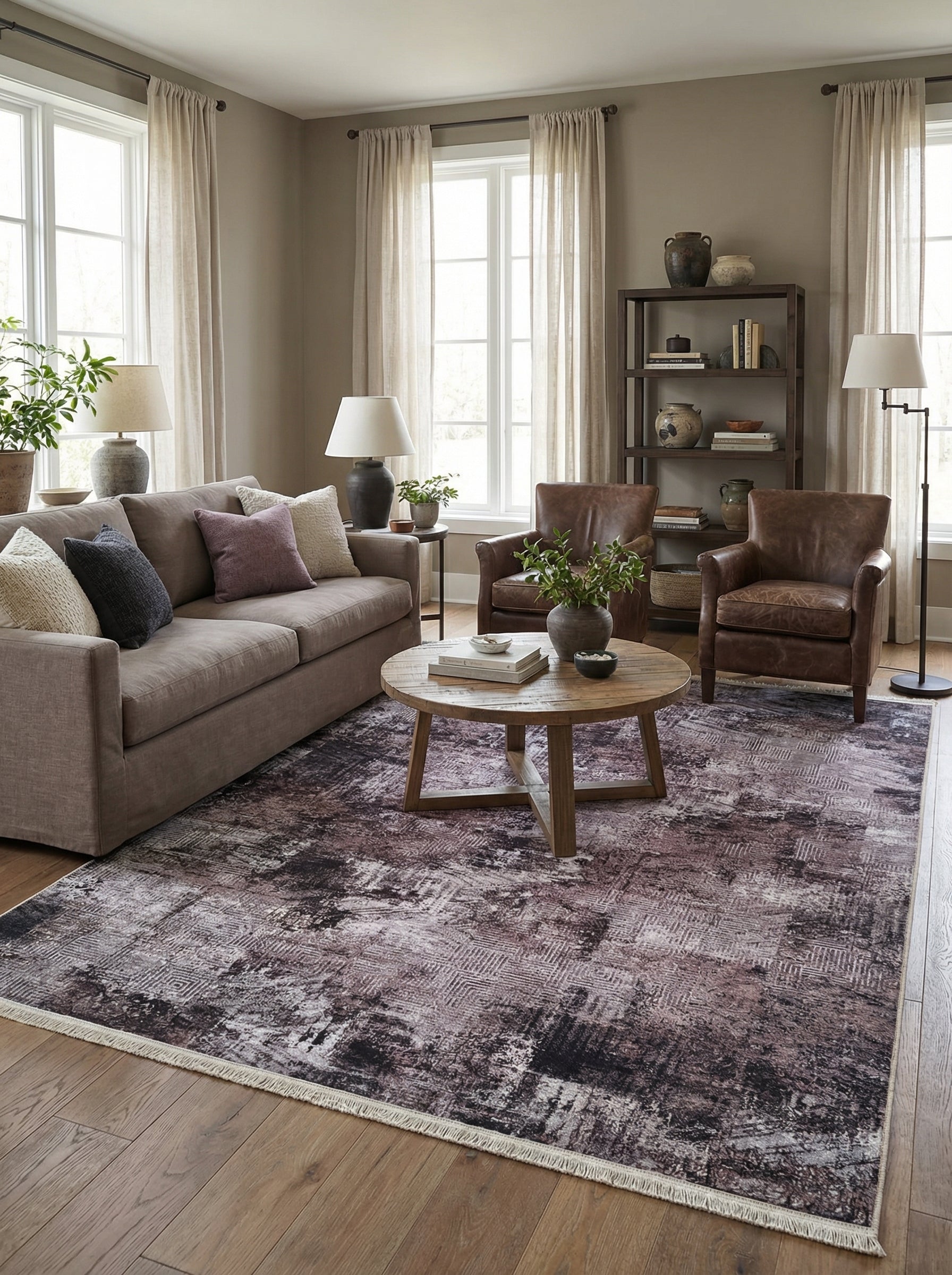 Tapis rectangulaire aux motifs abstraits prune, gris, crème et noir, avec franges claires, dans un salon