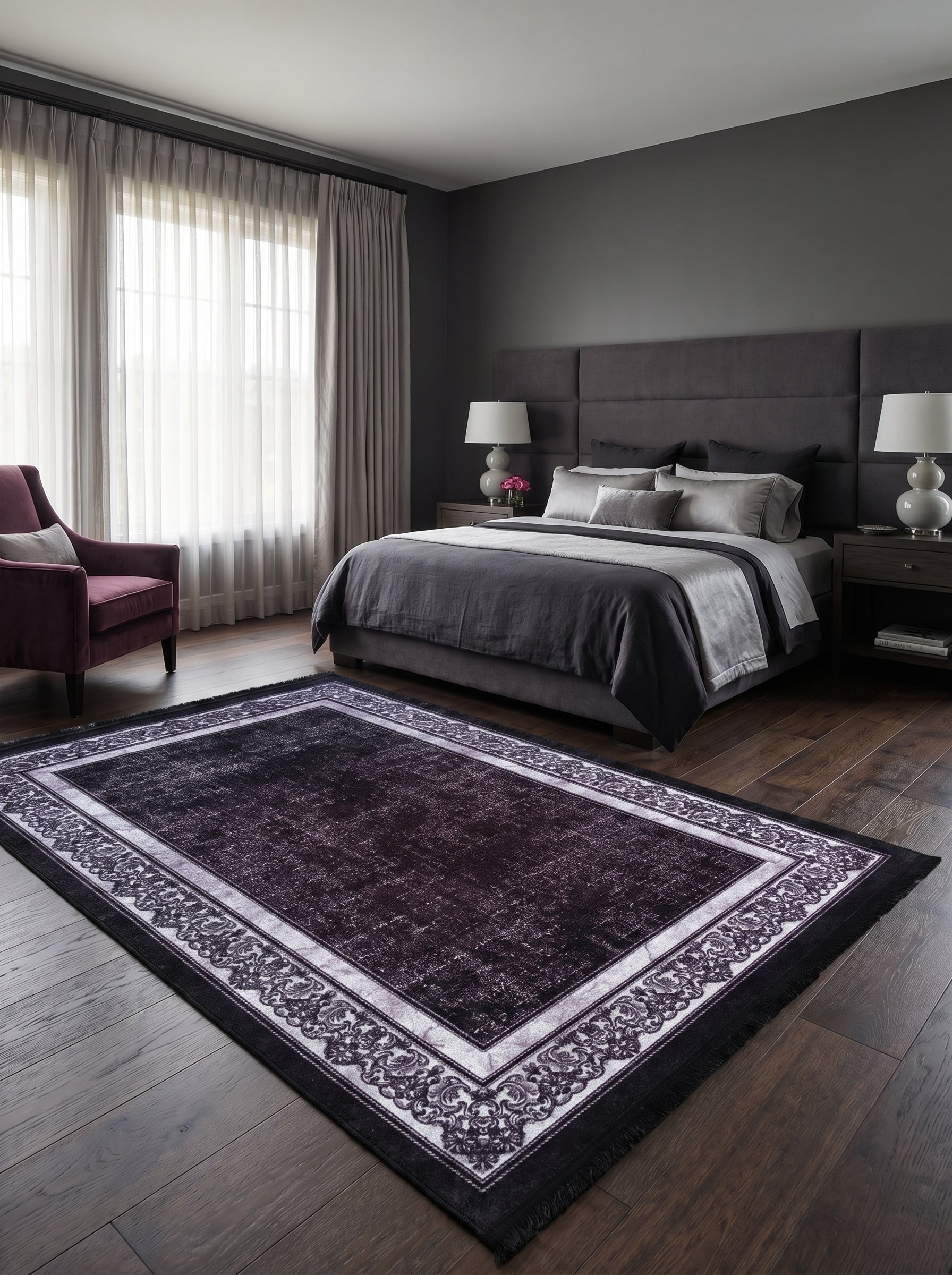 Tapis rectangulaire violet délavé et gris clair avec motifs floraux ornementaux, sur un plancher de bois sombre dans une chambre