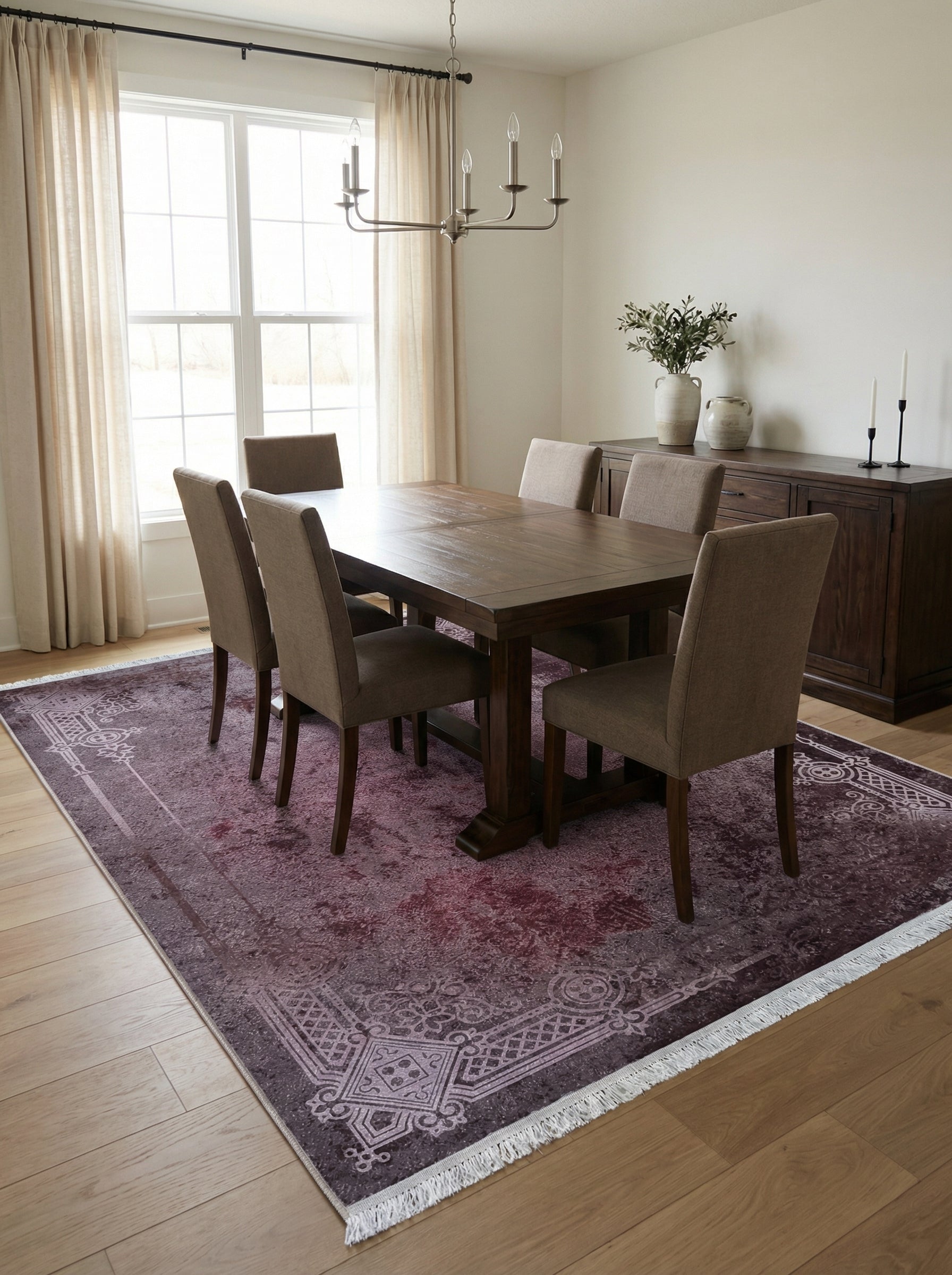 Tapis rectangulaire violet foncé avec motifs floraux et géométriques délavés, bordé de franges, dans une salle à manger