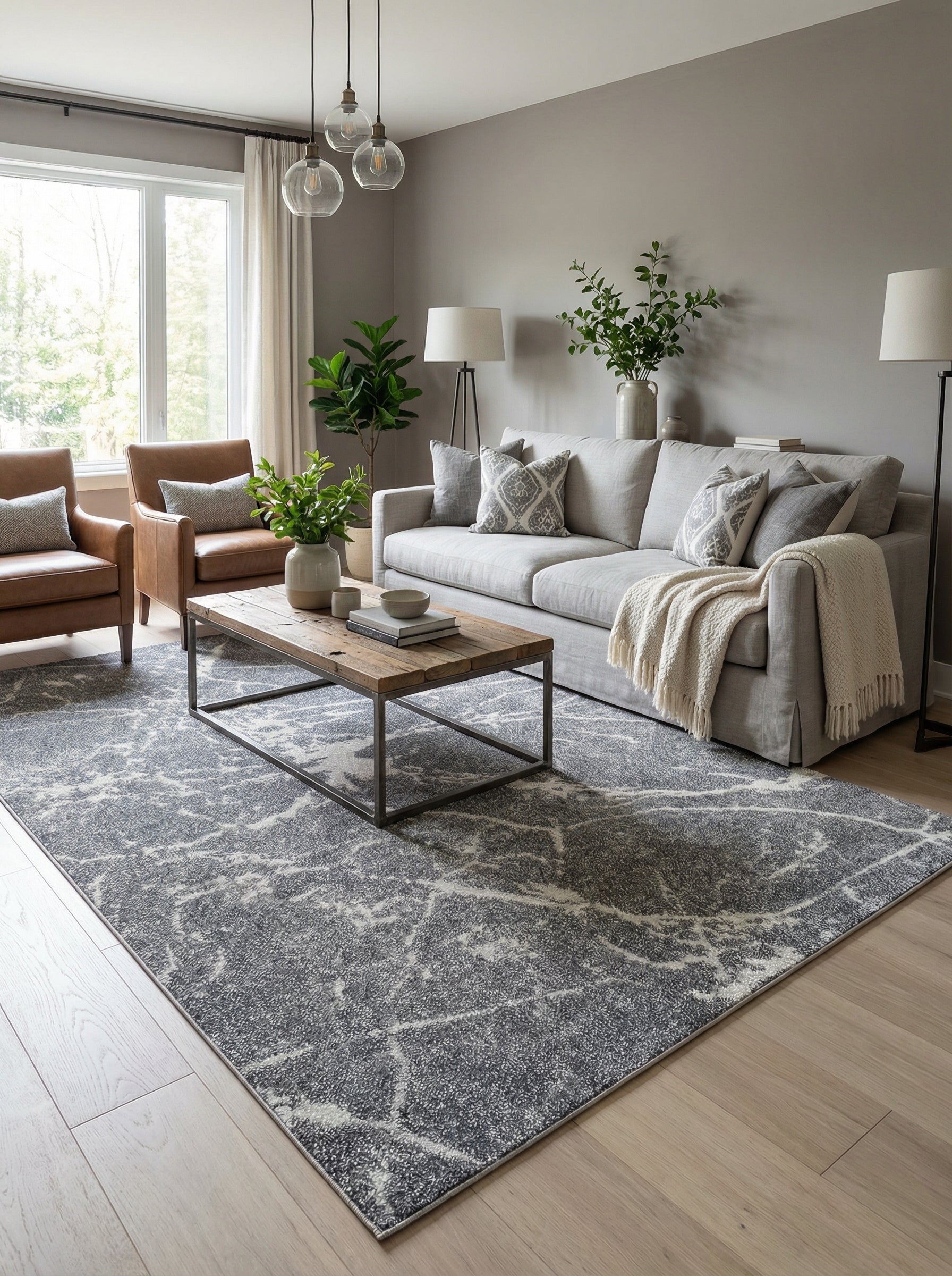 Tapis rectangulaire gris anthracite texturé, orné de motifs abstraits blancs et gris clair, au centre d'un salon moderne