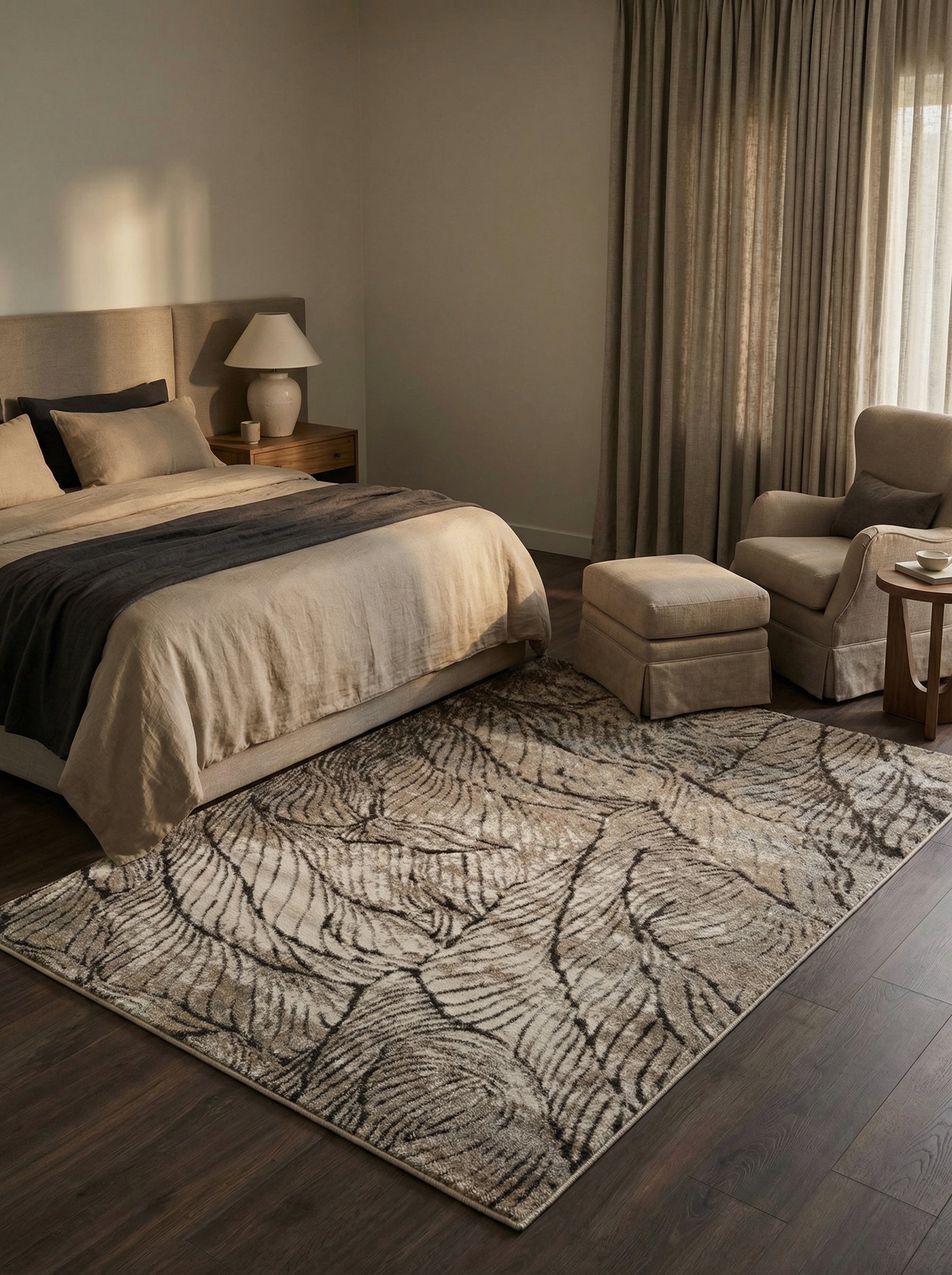 Tapis rectangulaire aux motifs de feuilles stylisées beige clair et marron foncé, posé sur un parquet dans une chambre