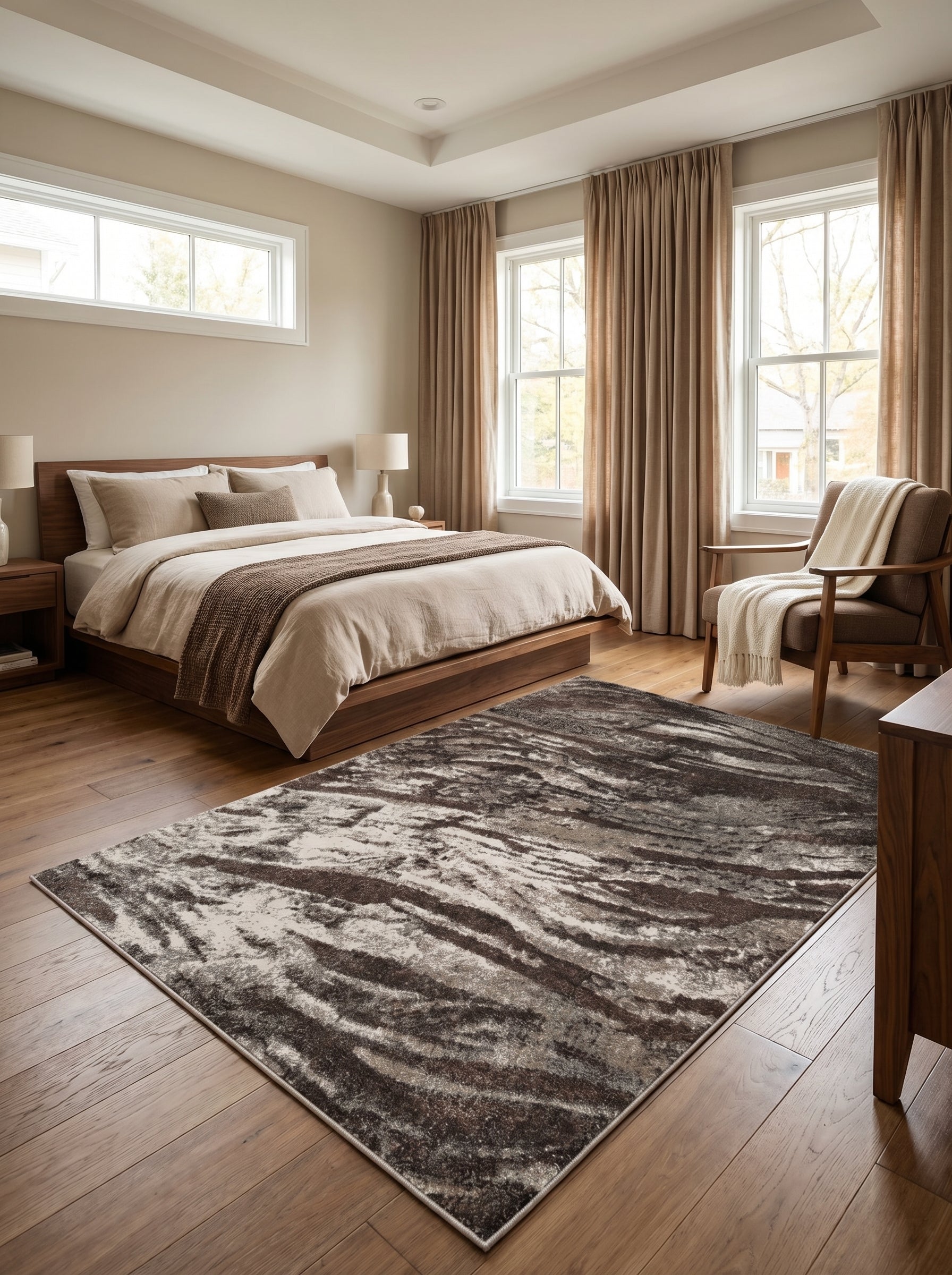 Tapis rectangulaire aux motifs abstraits ondoyants dans les tons marron, beige et gris, sur le parquet d'une chambre