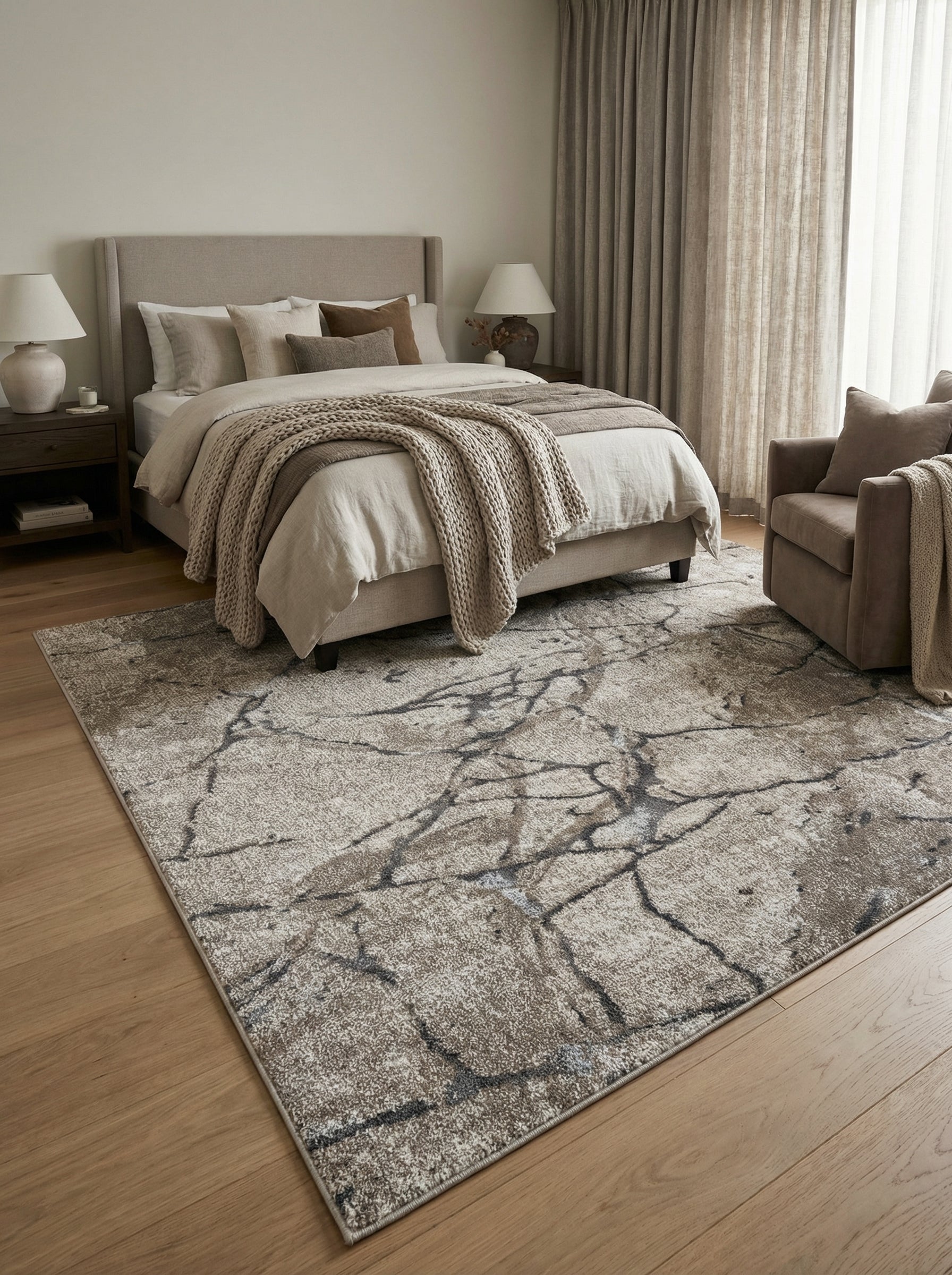 Tapis rectangulaire texturé beige et gris clair avec motifs abstraits de fissures gris foncé, dans une chambre moderne