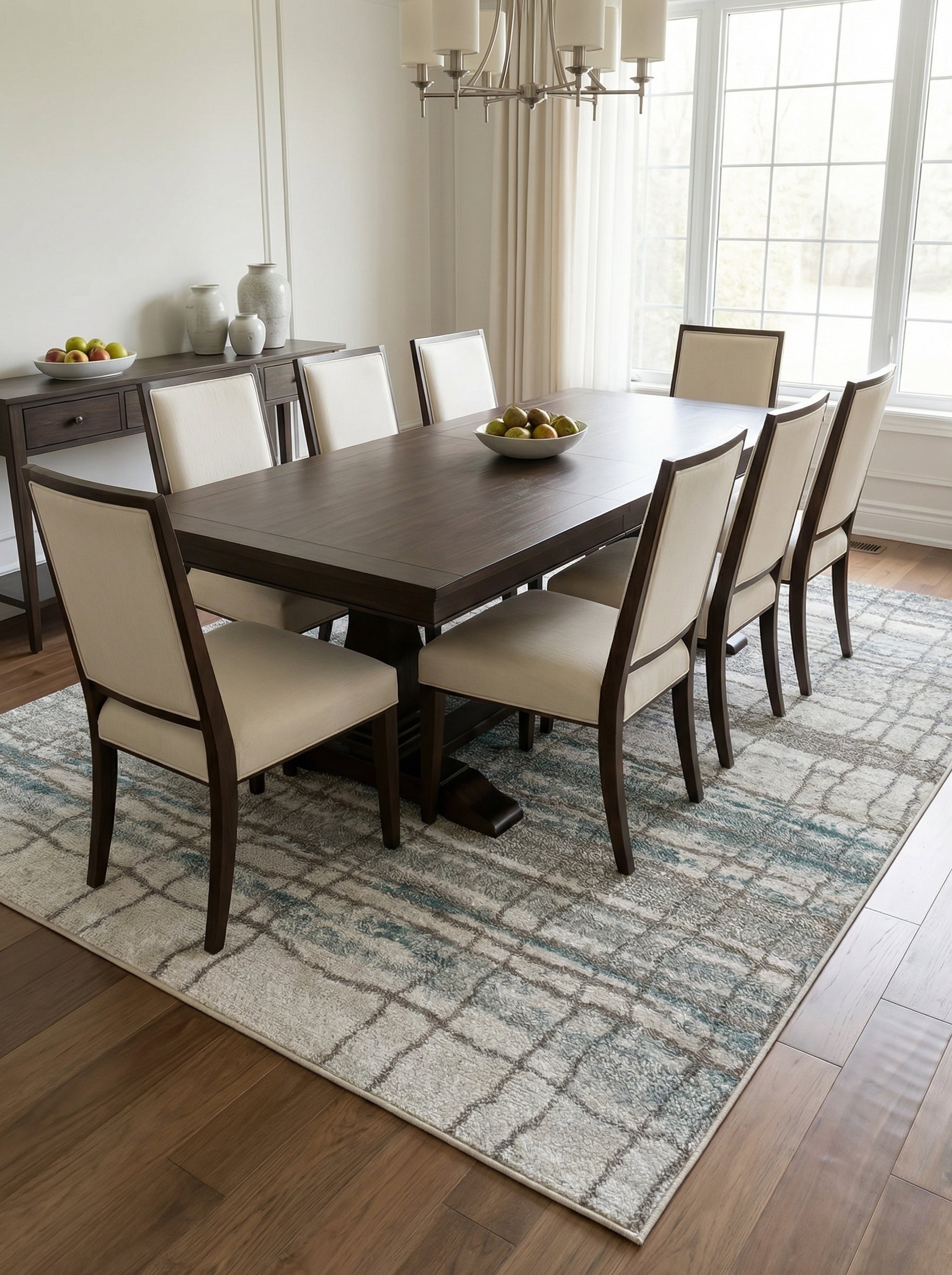 Tapis rectangulaire à motifs de grille déstructurée gris clair, beige et bleu-vert, dans une salle à manger