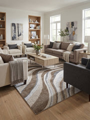 Tapis rectangulaire à motifs ondulés marron, beige, gris et blanc sur parquet clair dans salon moderne