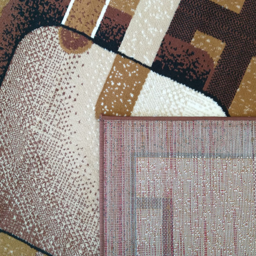 Tapis à motifs géométriques abstraits marron, beige, noir et blanc avec des zones mouchetées, un coin replié expose son dos tissé